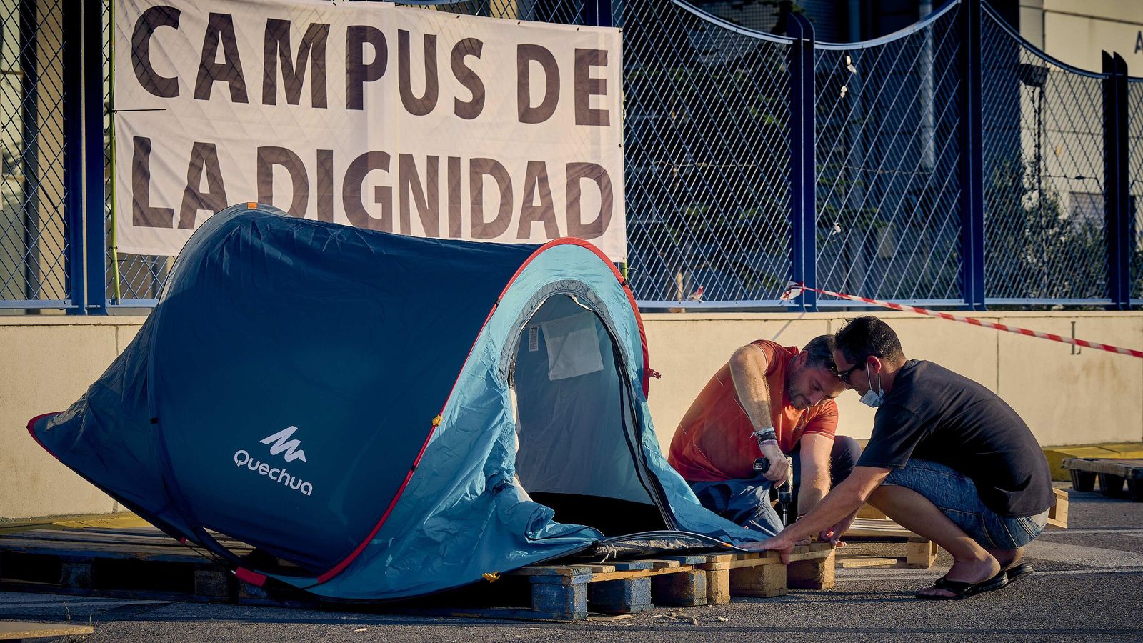 Dos de los trabajadores montan una caseta en la que pasar la noche