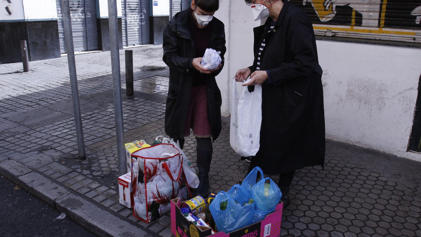 Esperando al taxista que viene a recoger las compras urgentes en la calle Feria.