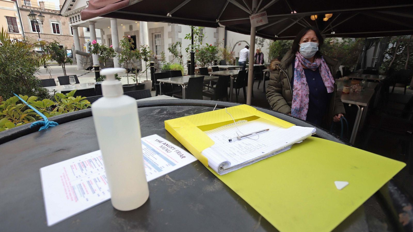 Gel hidroalcohólico y una lista para dejar el nombre en un bar de Gibraltar.