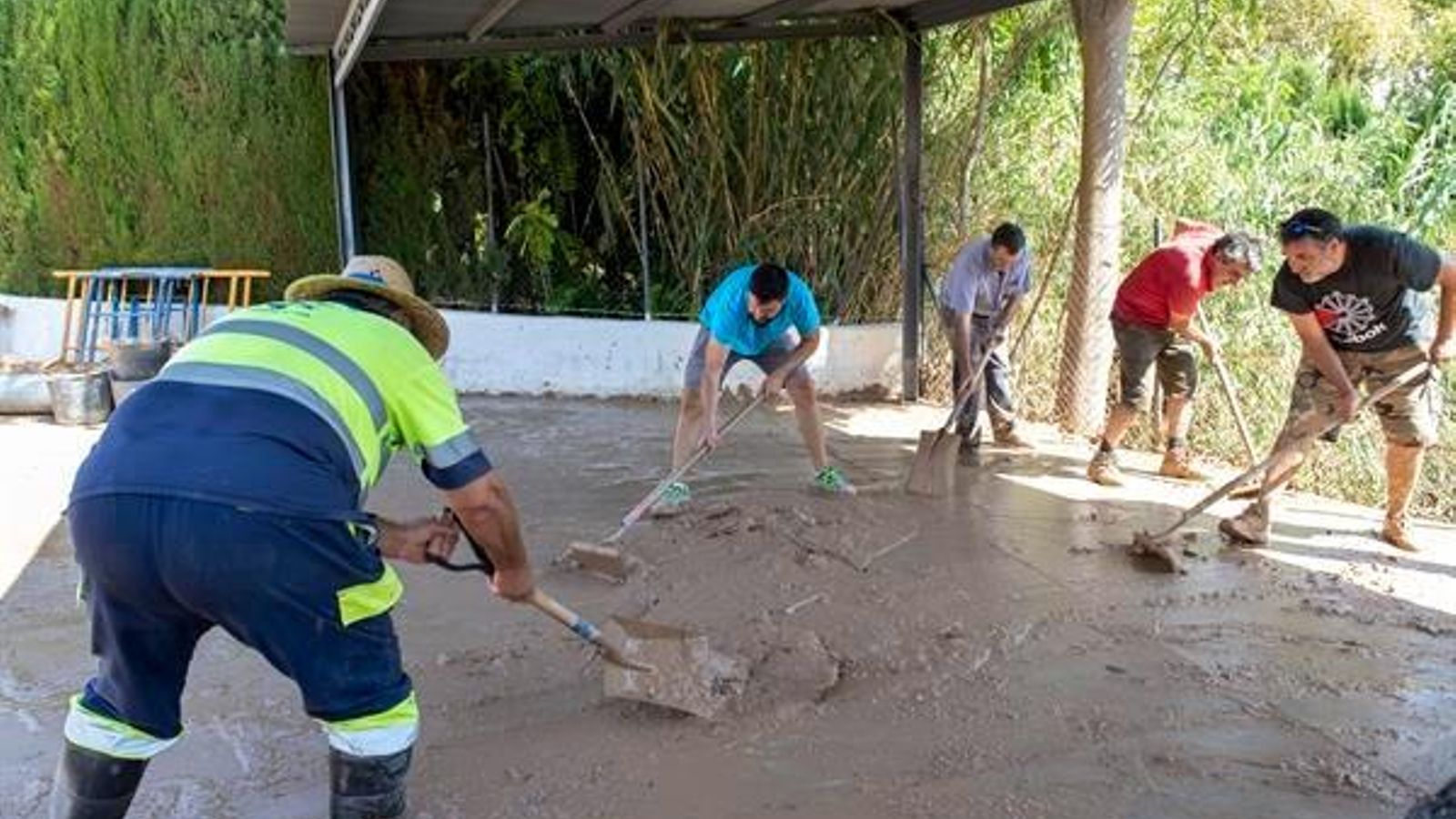 Los vecinos limpian el barro tras el temporal.