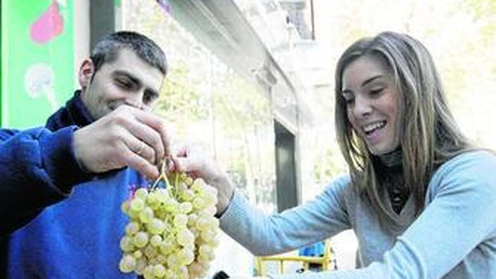 Dos jóvenes con un racimo de uvas