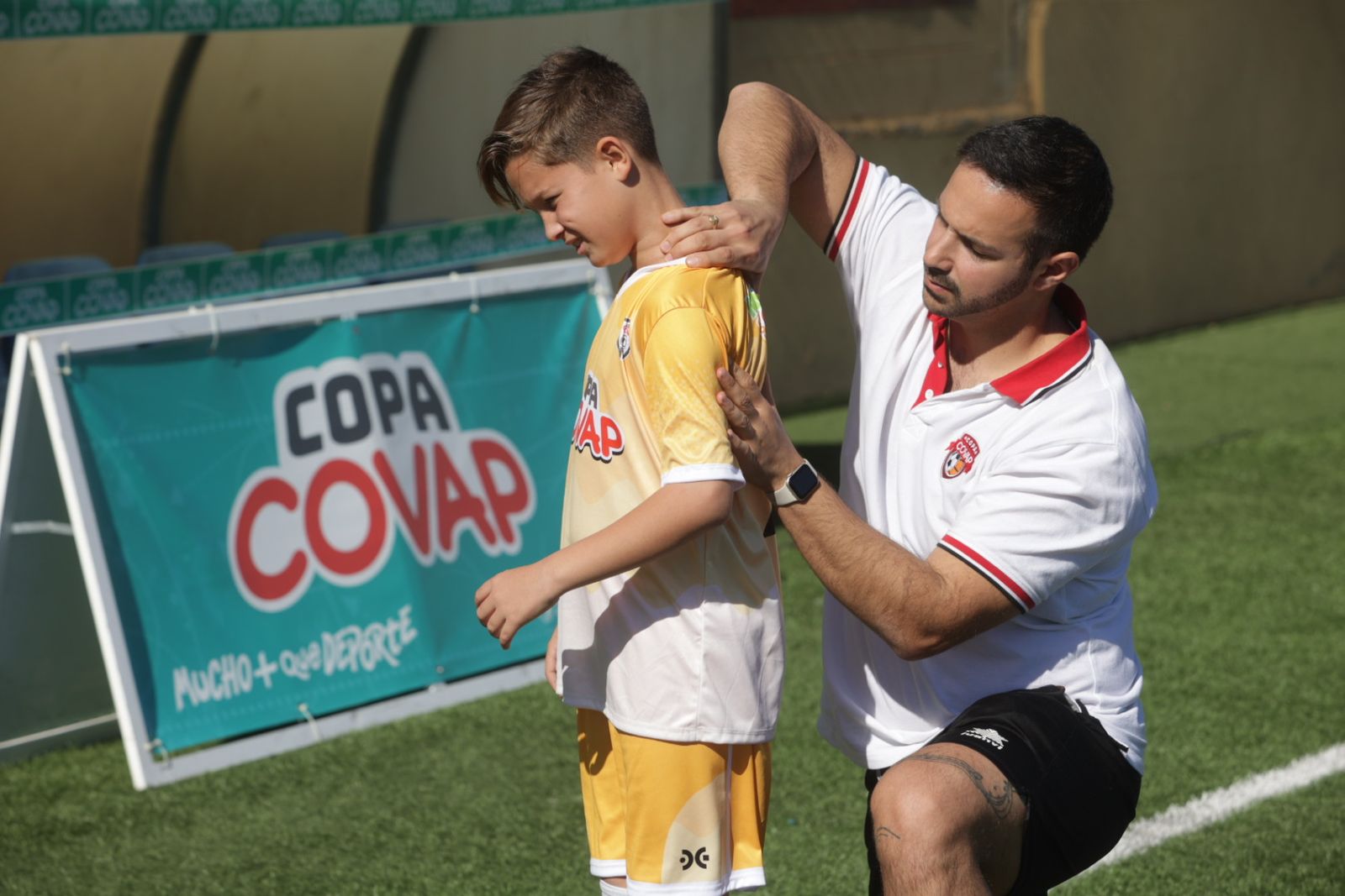 Un fisio atiene a un niño durante un partido de la Copa Covap.