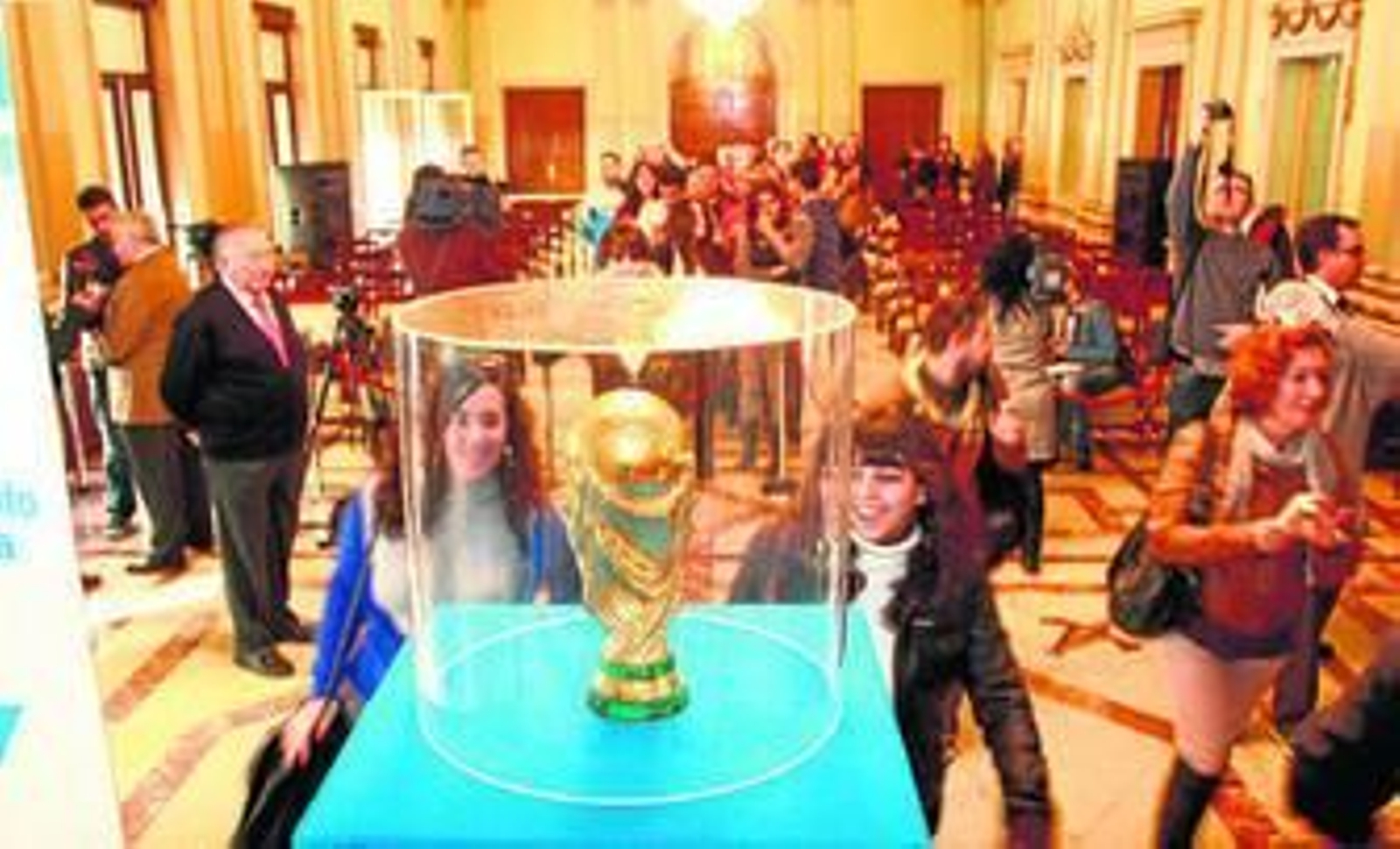 Dos jóvenes se acercan a la Copa del Mundo en una de sus exposiciones en Huelva.