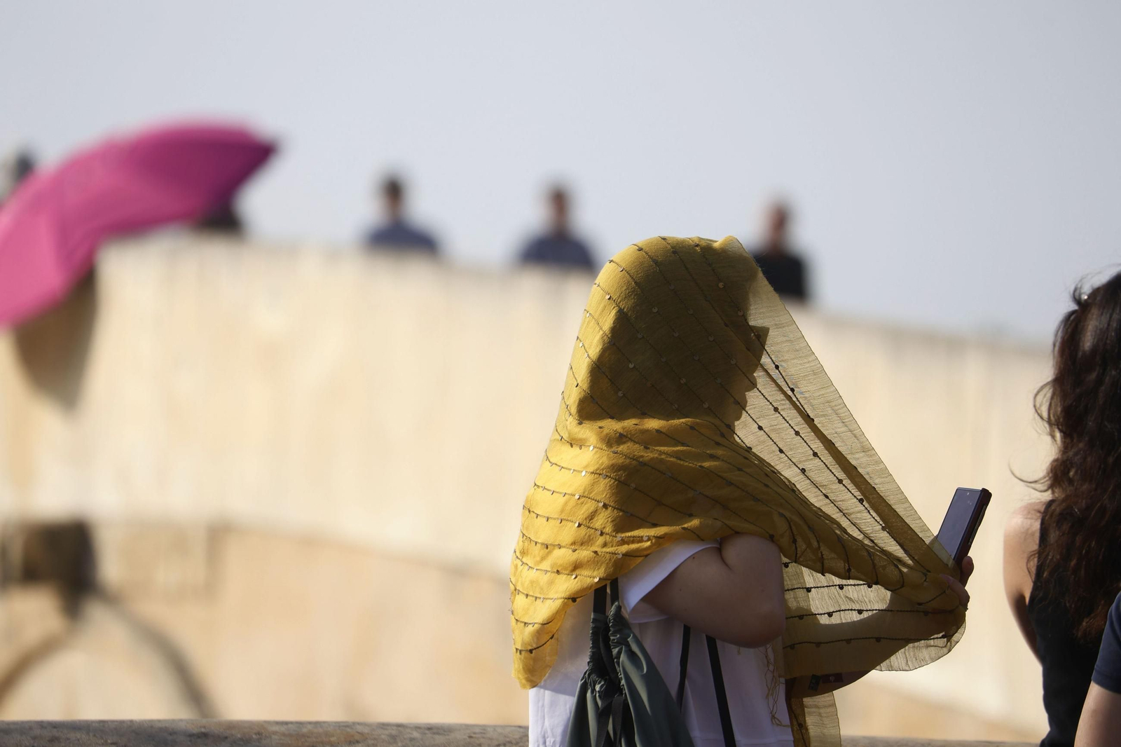 Una turista se protege del sol en el Puente Romano.