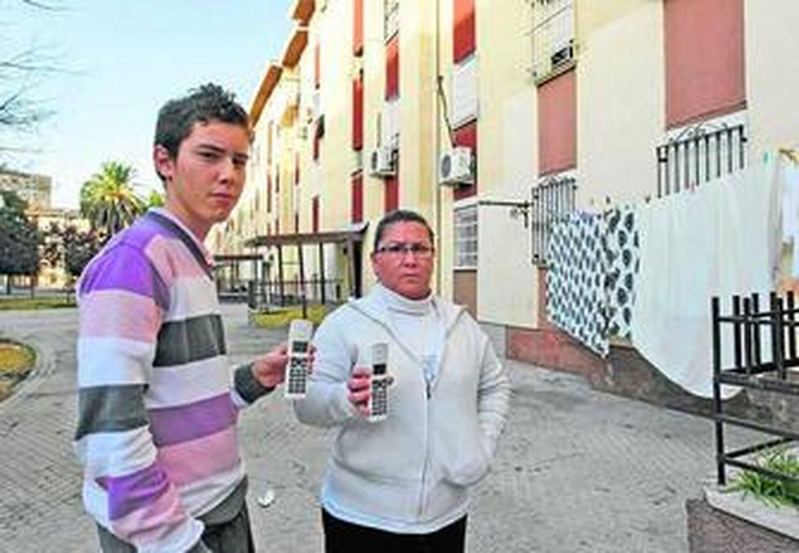 Víctor Asencio y su madre, Camen Isabel Regaña, muestran los teléfonos inalámbricos que no pueden usar.
