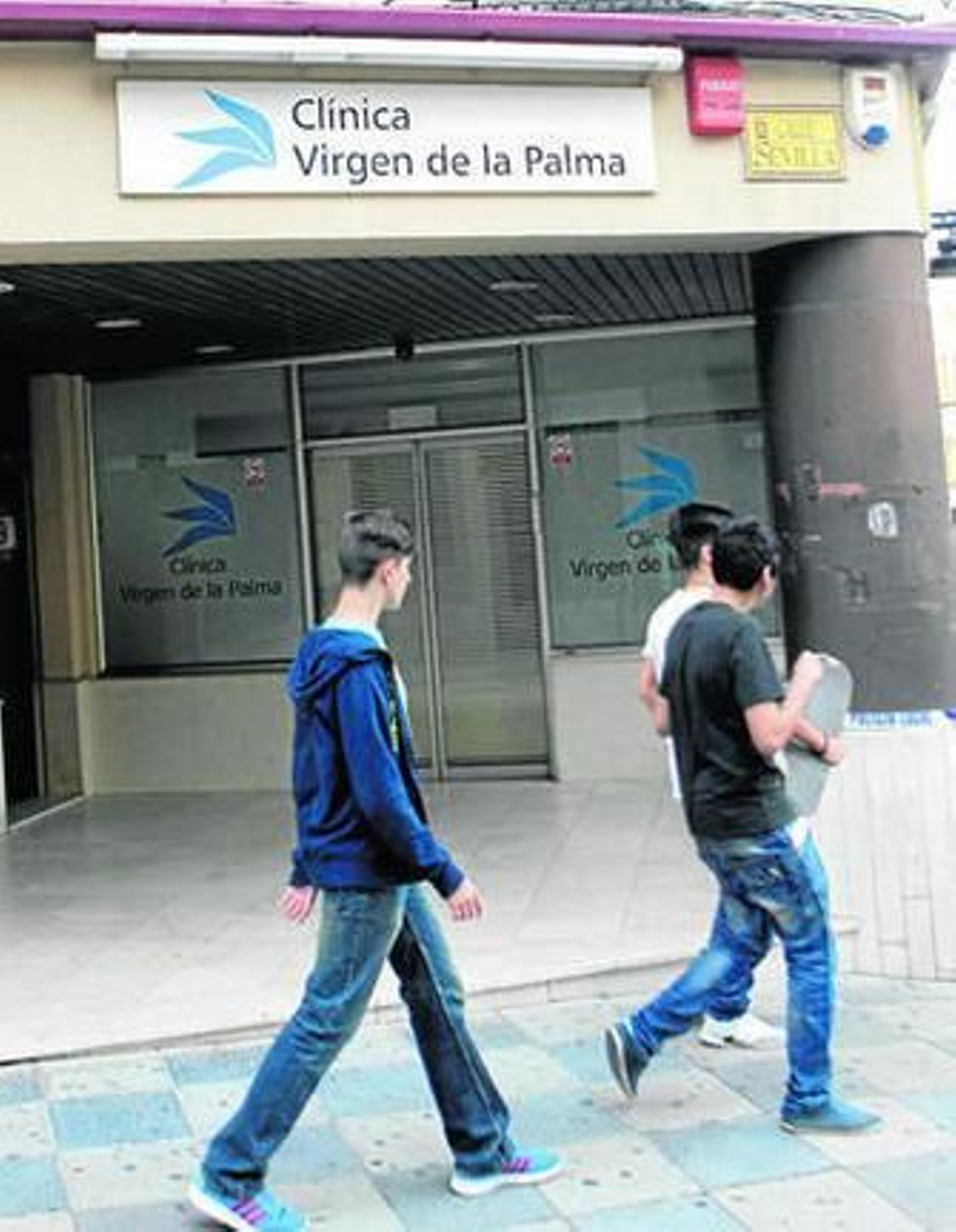 Tres jóvenes pasan por delante de la entrada a la clínica Virgen de la Palma, ayer en Algeciras. Tres jóvenes pasan por delante de la entrada a la clínica Virgen de la Palma, ayer en Algeciras.