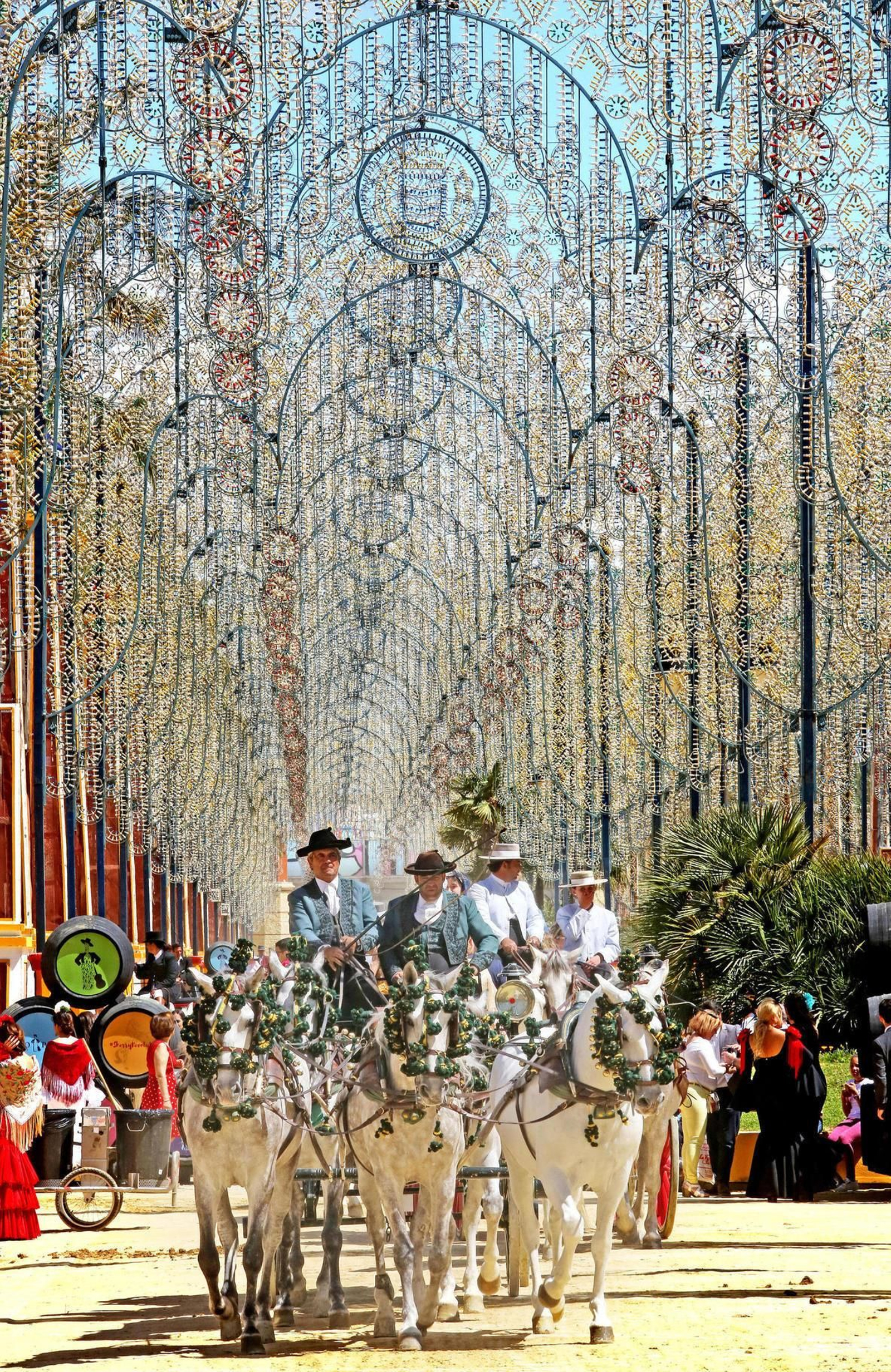 El encaje de luces preside el paseo de caballos de la Feria.