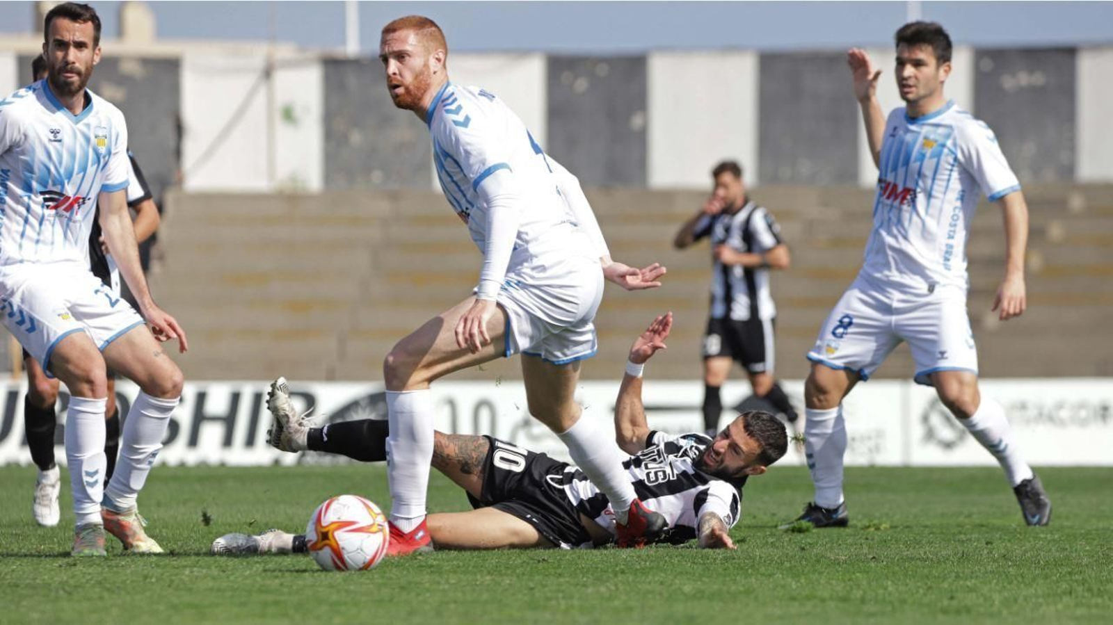 Antoñito, cuya sustitución provocó el enfado del público,  pelea por el balón desde el suelo