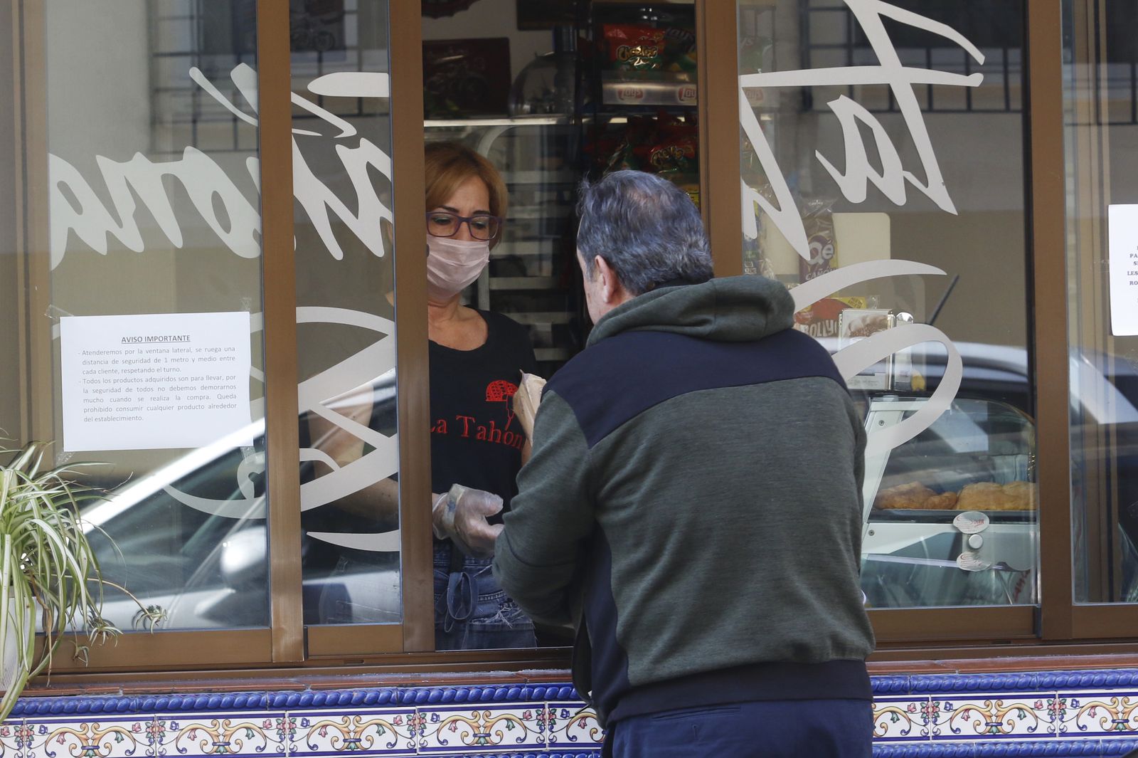 Una mujer atiende a un cliente en una tienda.