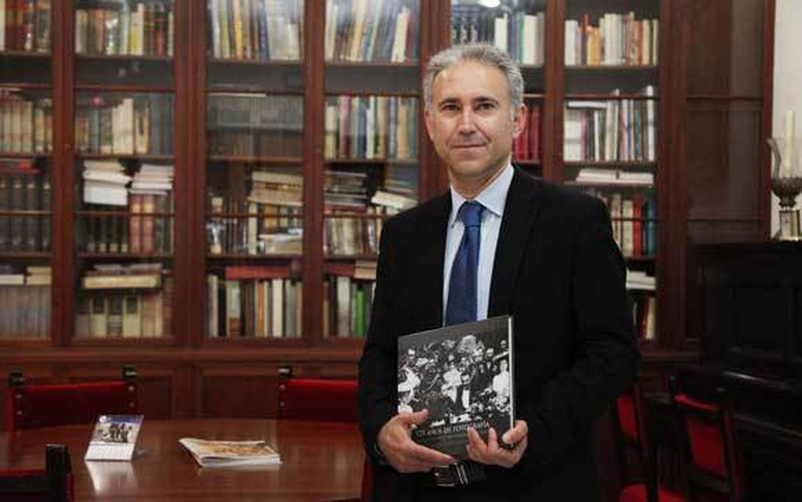 Adrián Fatou posa, en junio de 2014, con su libro 175 años de fotografía, en la toma de posesión como académico. /Vanesa Lobo