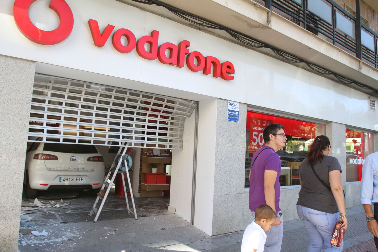 Estado en el que quedó la puerta del local afectado, aún con el vehículio utilizado en el interior.