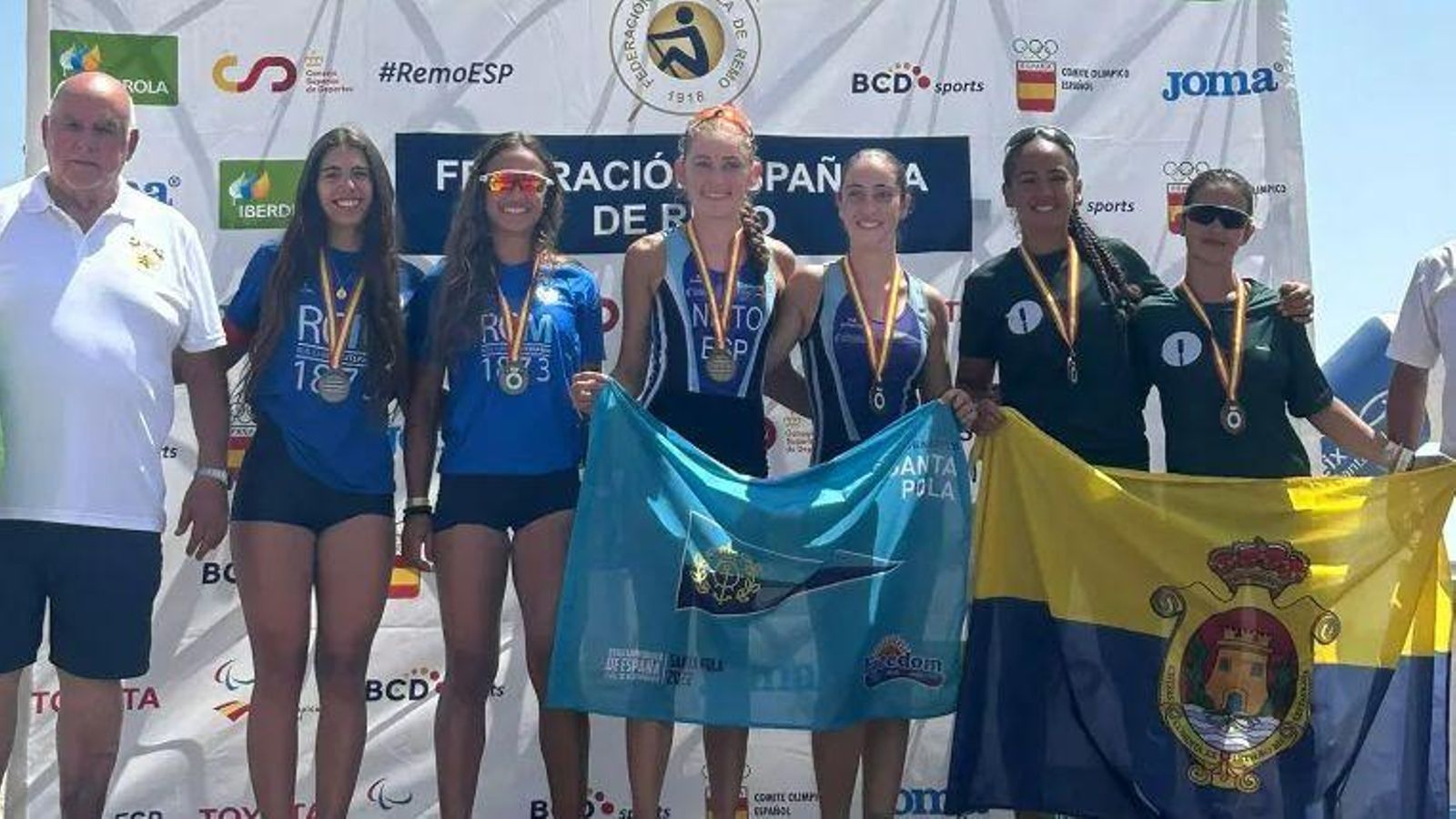 Las remeras del 2x junior femenino con la medalla de plata en el 'podium'.
