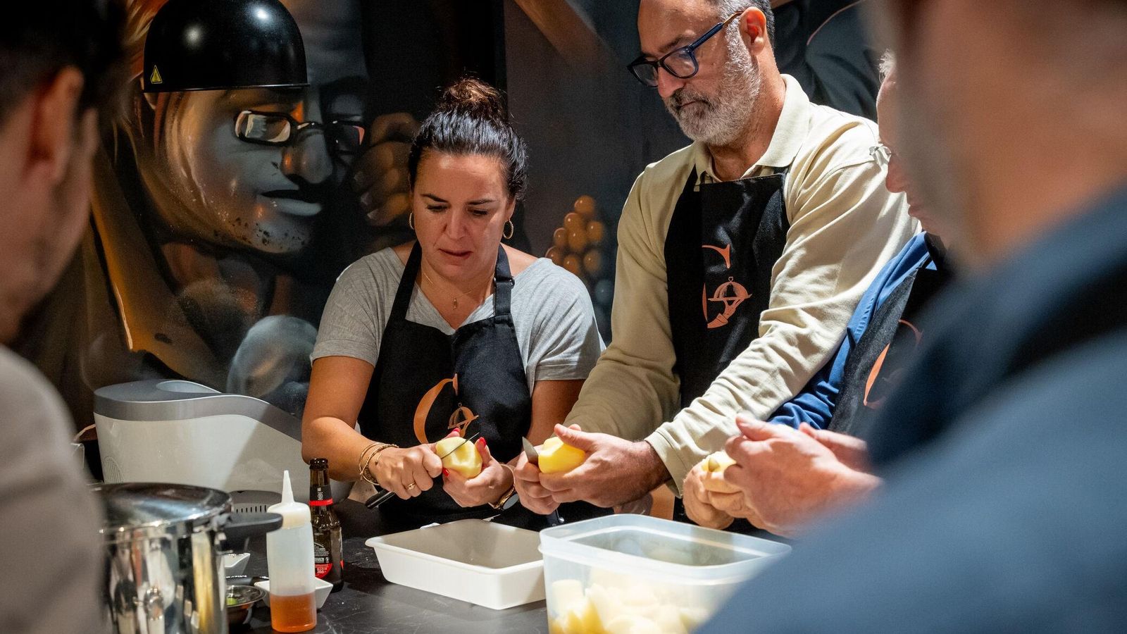 Dos alumnos pelando patatas en una clase.