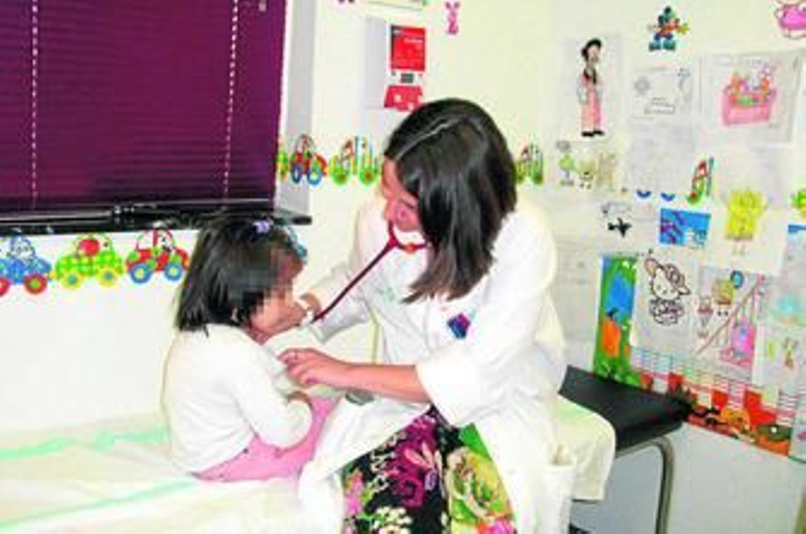 Una pediatra atiende a una niña.