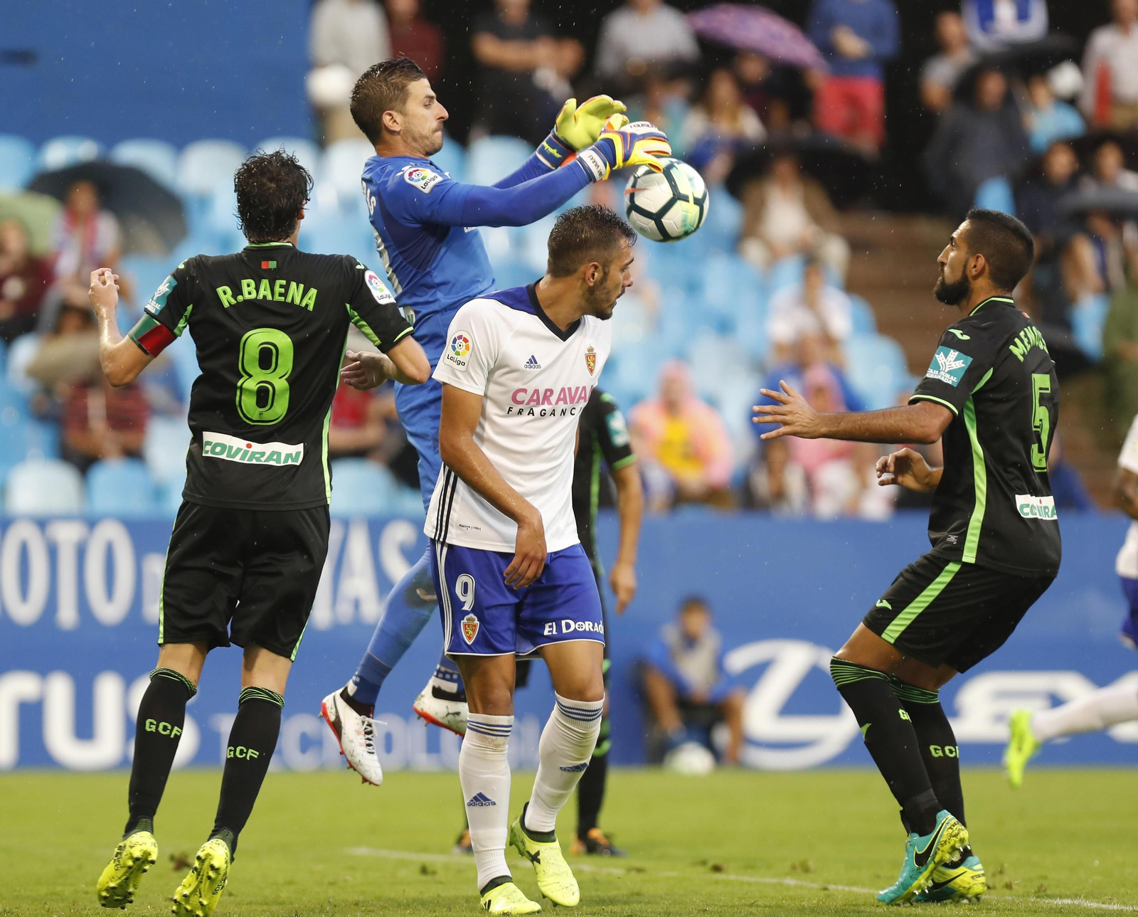 Javi Varas intenta atrapar el balón en presencia de Raúl Baena.