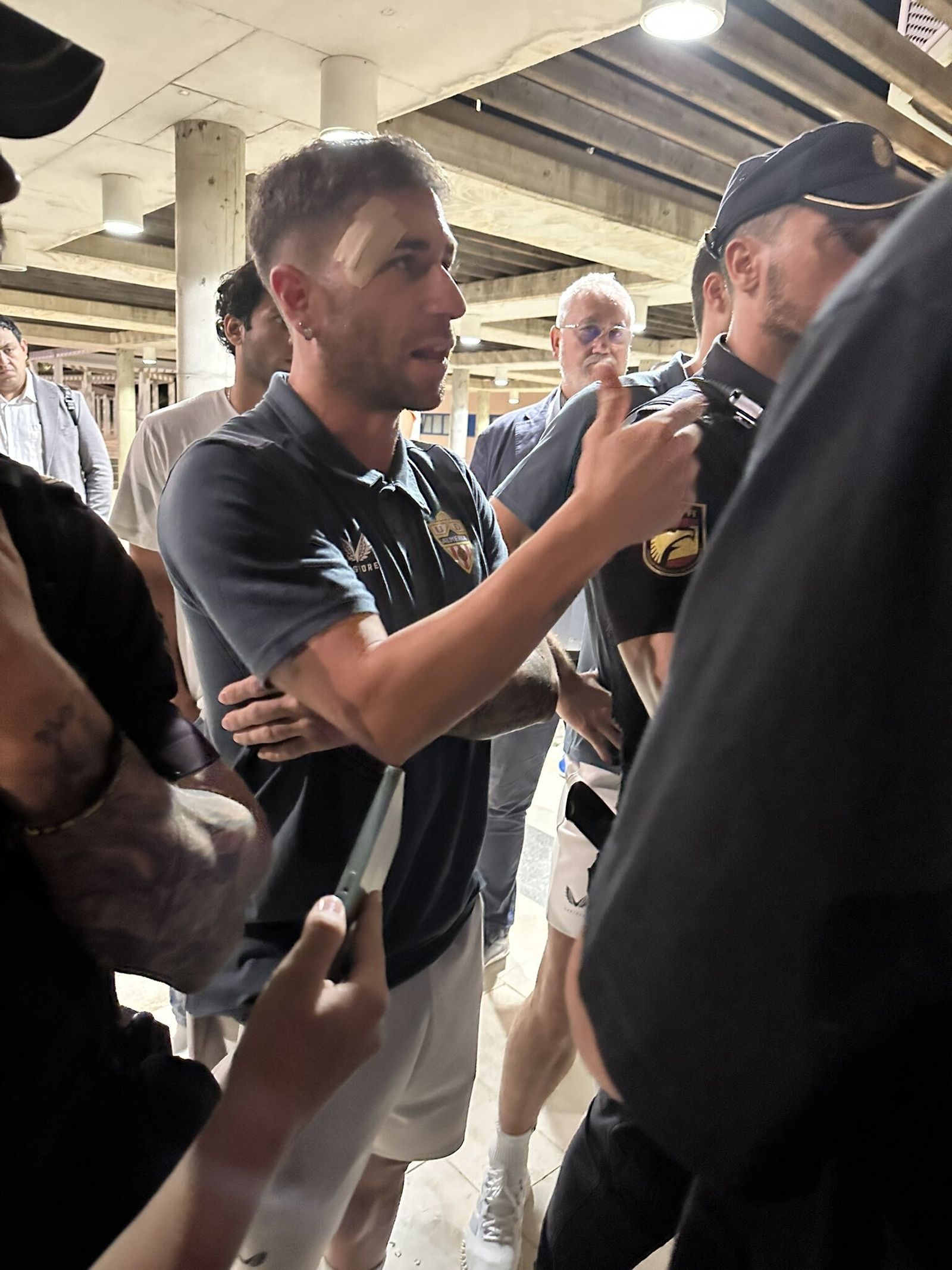 Embarba, escoltado por Policías, habla con simpatizantes rojiblancos en el aeropuerto a la vuelta de Sevilla