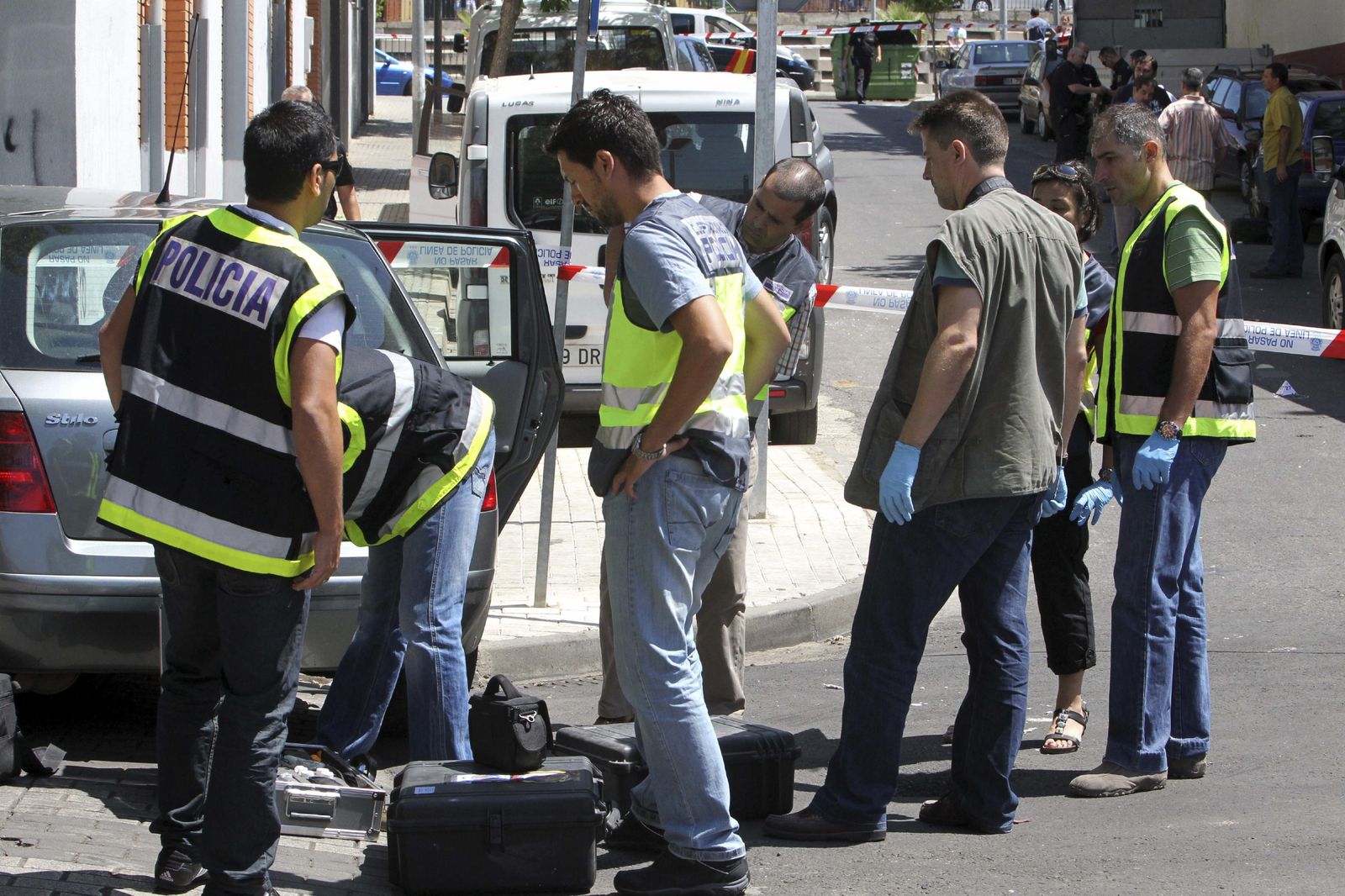 Varios policías buscan pruebas en la zona donde tuvo lugar un tiroteo.