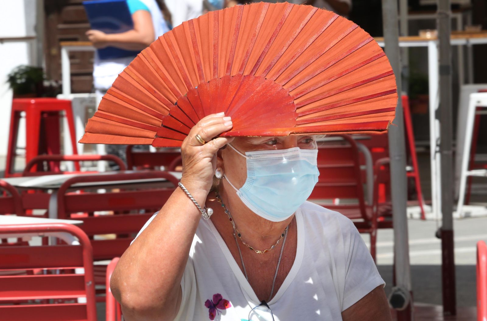 Una mujer sostiene un abanico para defenderse de los rayos del sol