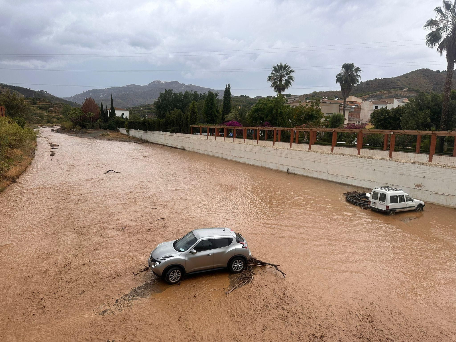 Los vehículos que se han quedado atrapados por la subida del cauce de río Benamargosa.