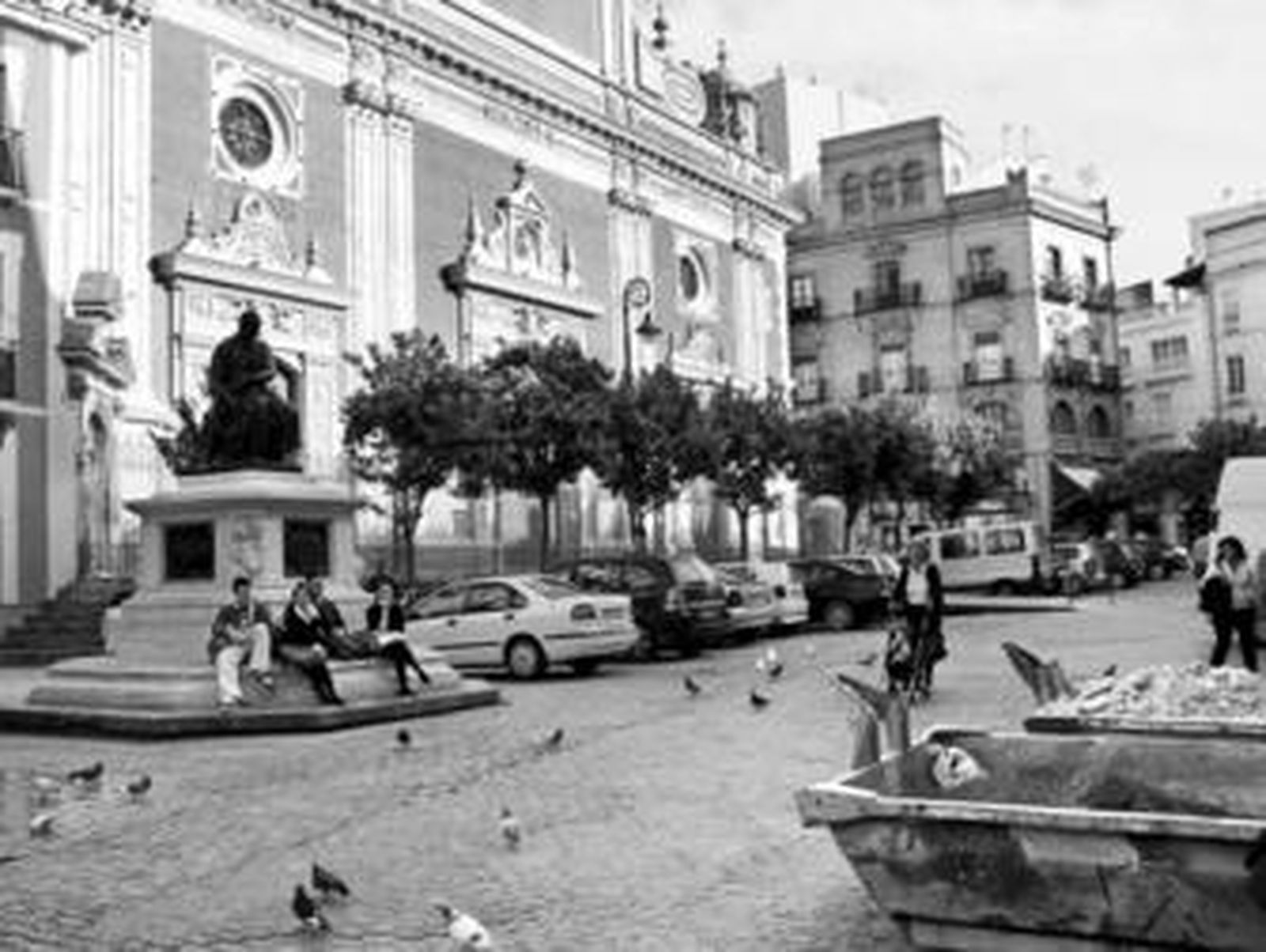 Aspecto actual de la Plaza del Salvador, con coches aparcados y cubas de obras cercanas.