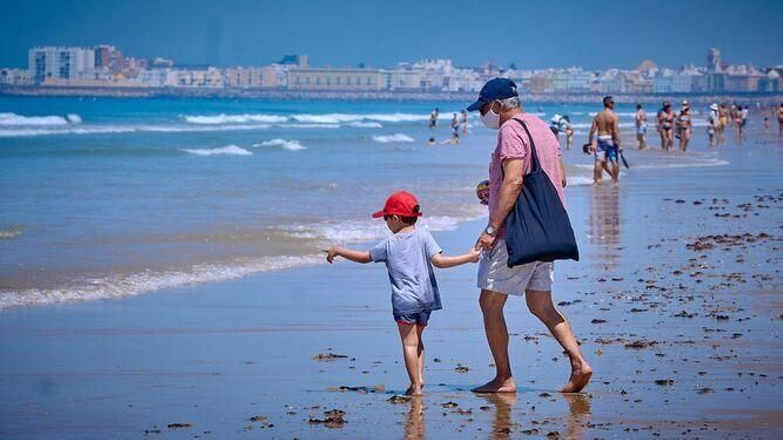 Un abuelo y su nieto en la playa de Cádiz