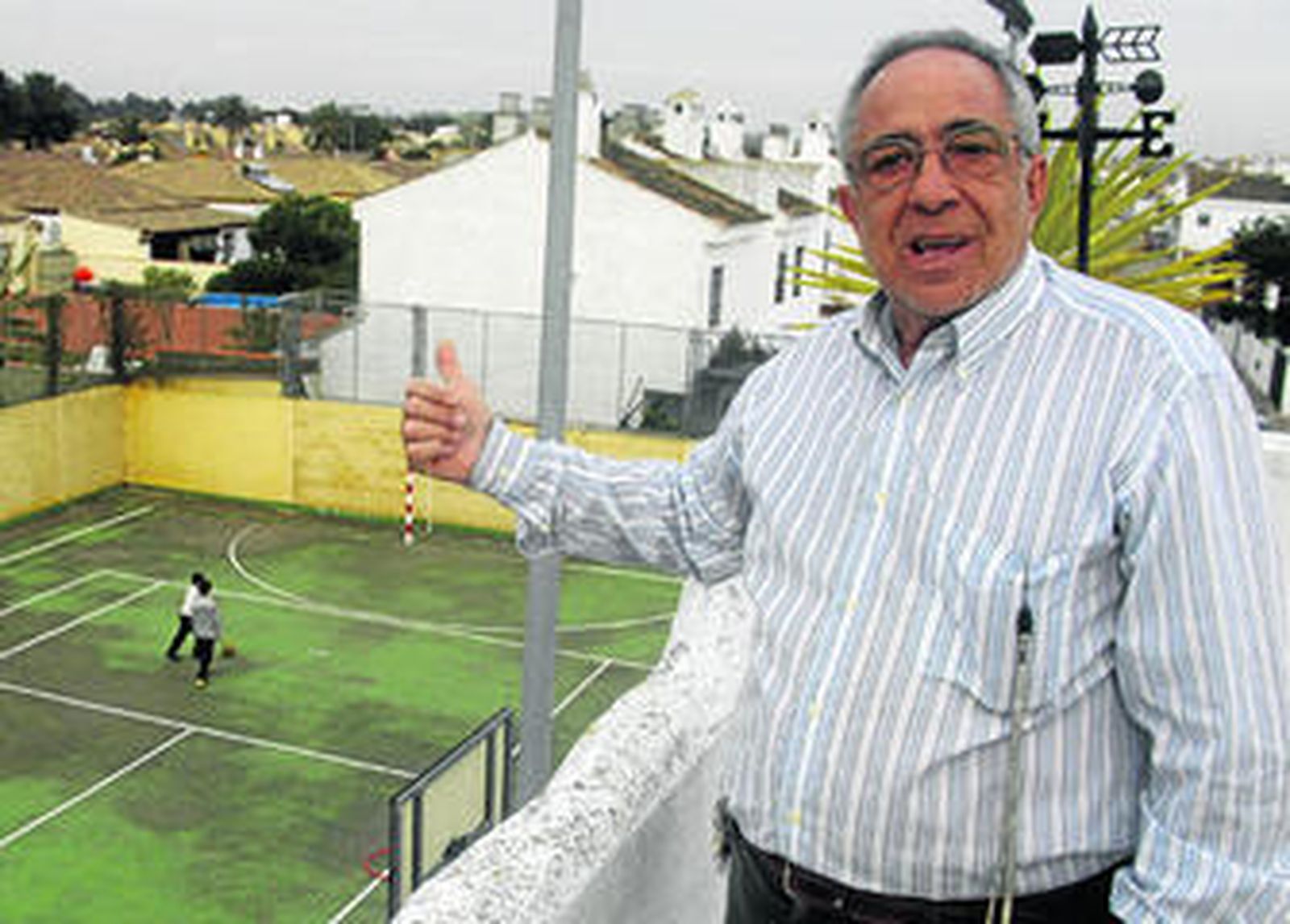 Marcelino Vidal en la azotea de su casa, en Real de la Barrosa, con la cancha deportiva al fondo.