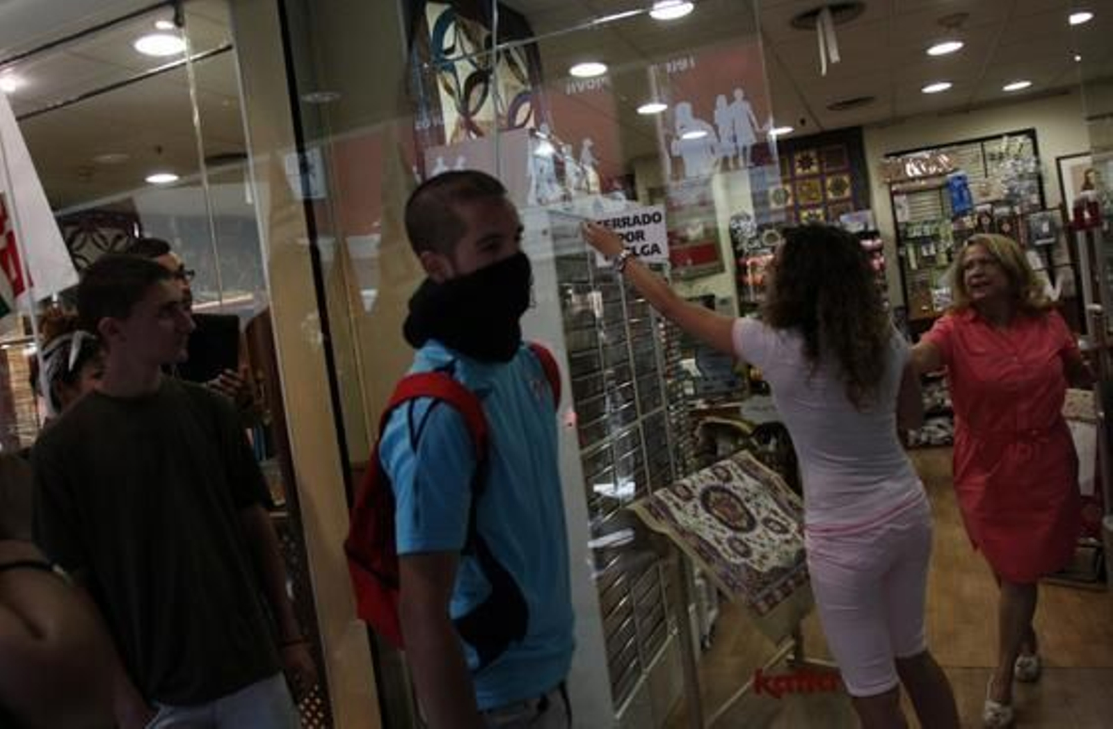 Los manifestantes se cuelan en un establecimiento para forzar su cierre.

Foto: Migue Fernández