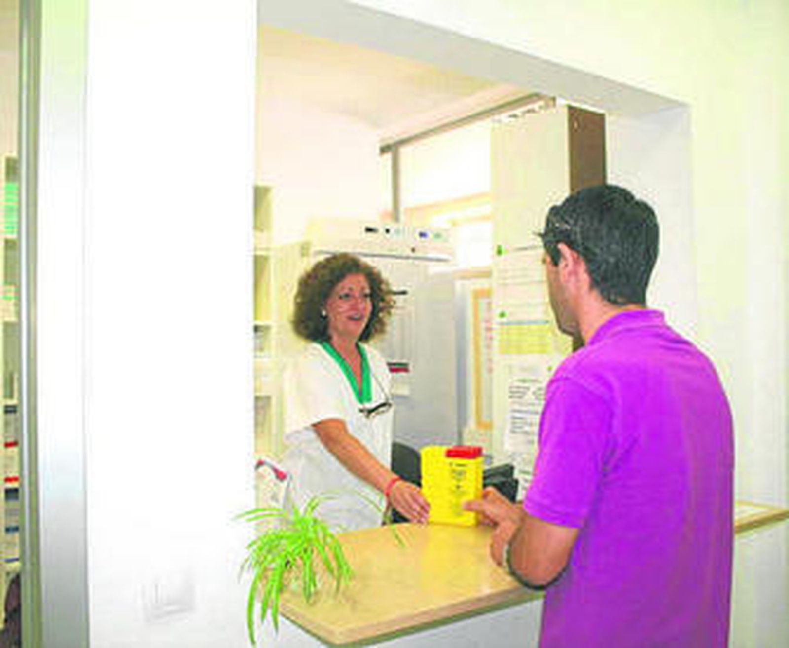 Una trabajadora de la farmacia del hospital atiende a un usuario.