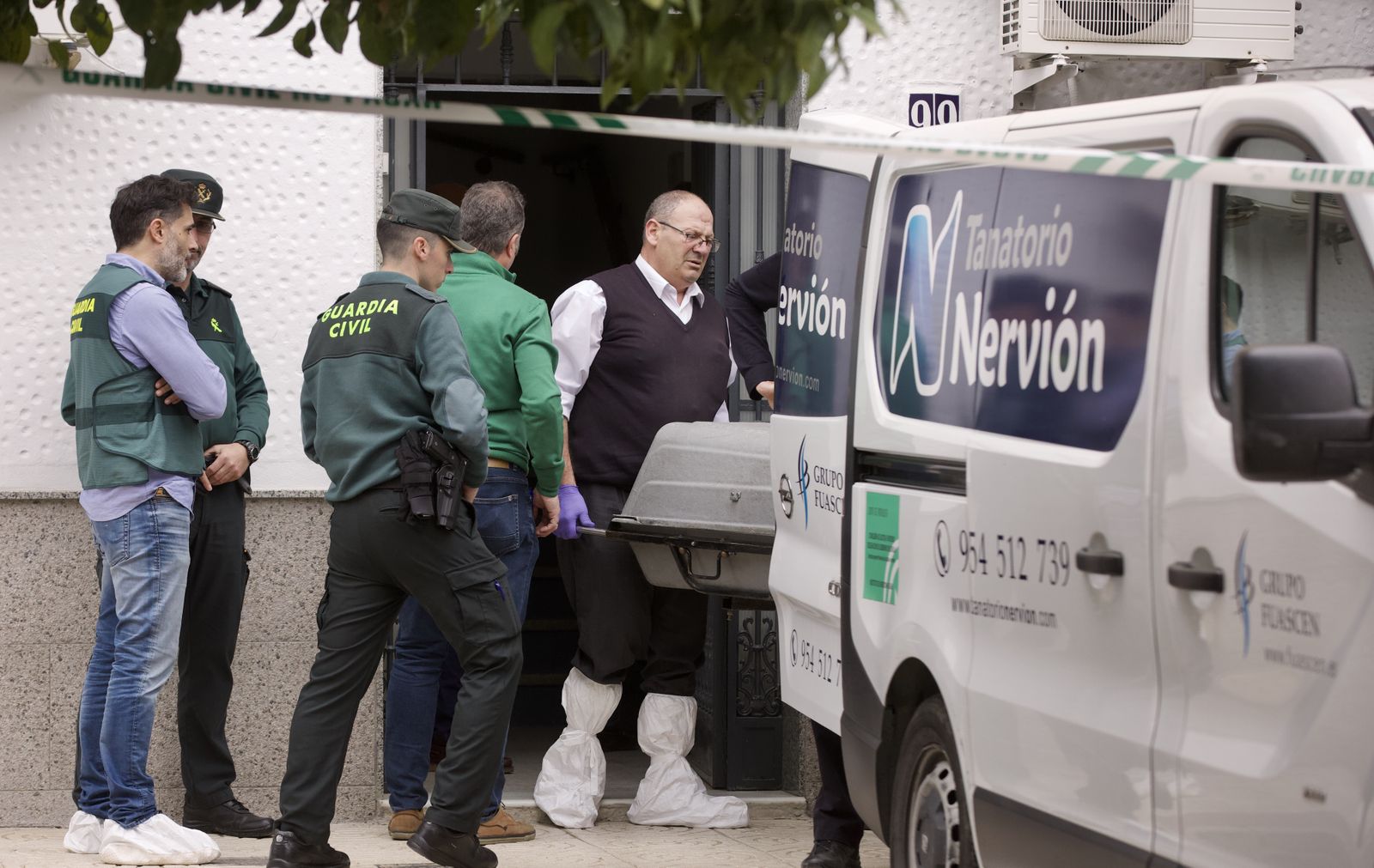 Un empleado del Tanatorio Nervión retira uno de los cadáveres hallados en Lora del Río.