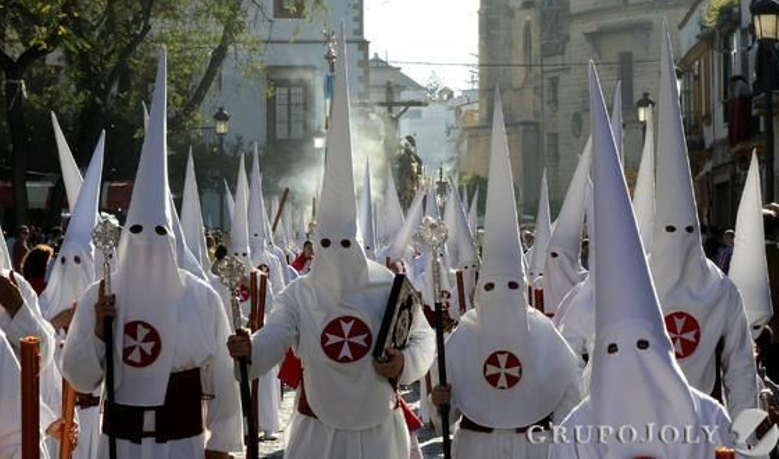 La presidencia del libro de reglas de la hermandad del Amor, con el misterio al fondo, en su paso por la calle Ancha mientras busca la Carrera Oficial.

Foto: Miguel Angel Gonzalez