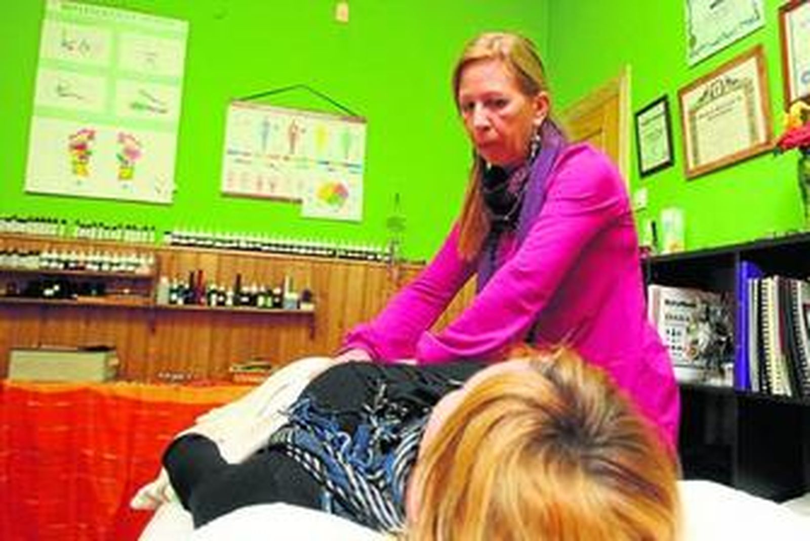 La terapeuta Nacha Hernández realiza una sesión de reiki a una joven.