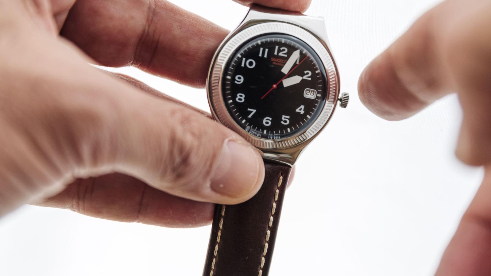 Persona cambia la hora de su reloj.