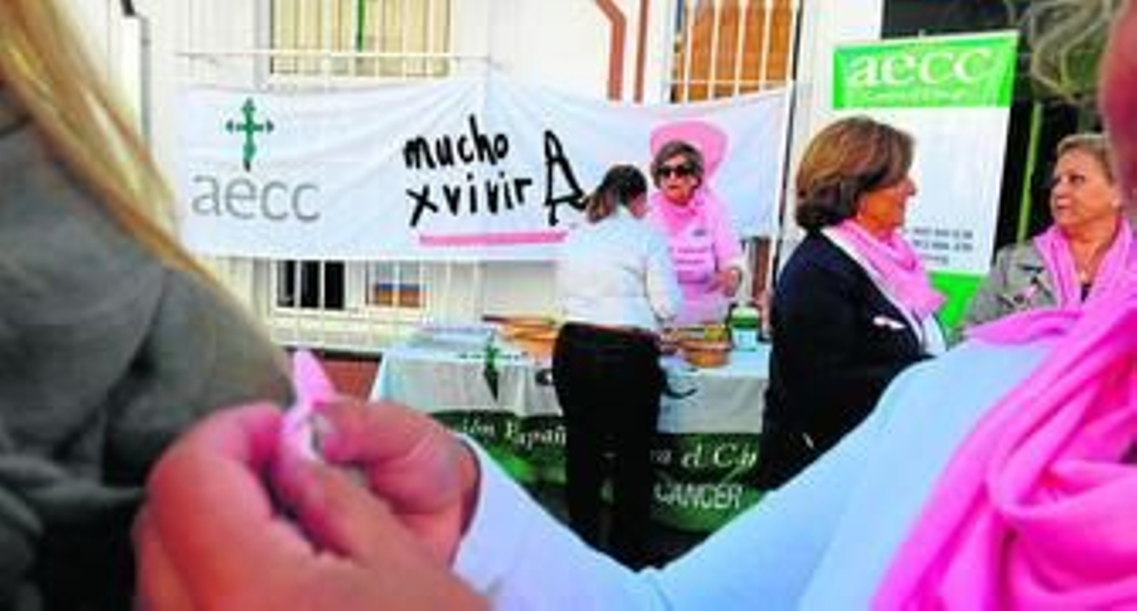 Prendiendo un lazo rosa, símbolo de la lucha contra el cáncer de mama.