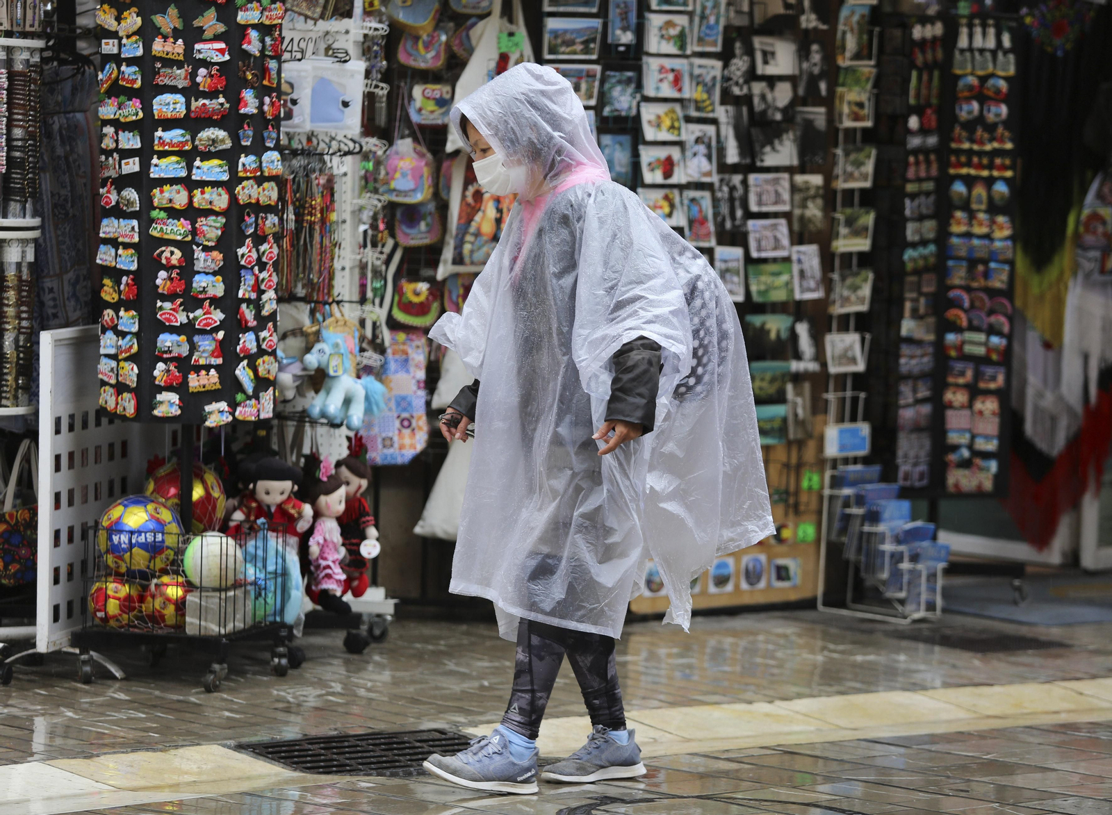 Una  mujer pasea por Málaga con chubasquero hace unos días