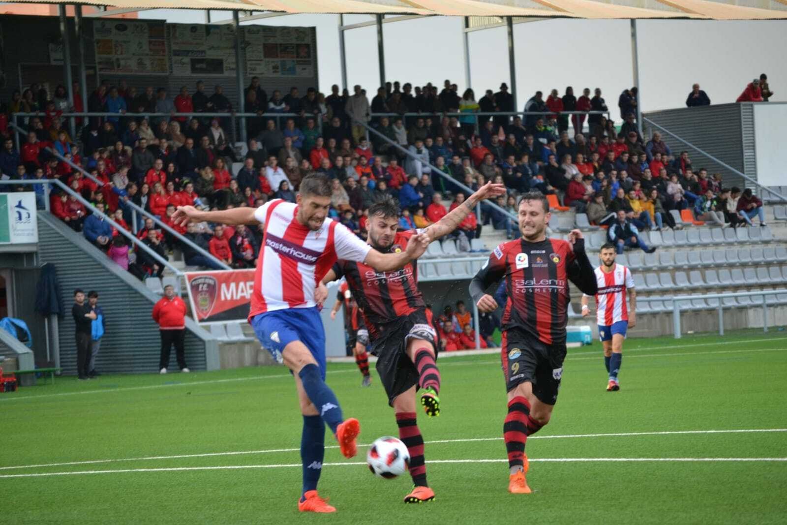Dos jugadores del Puente Genil presionan a un contrario en un partido de esta temporada.
