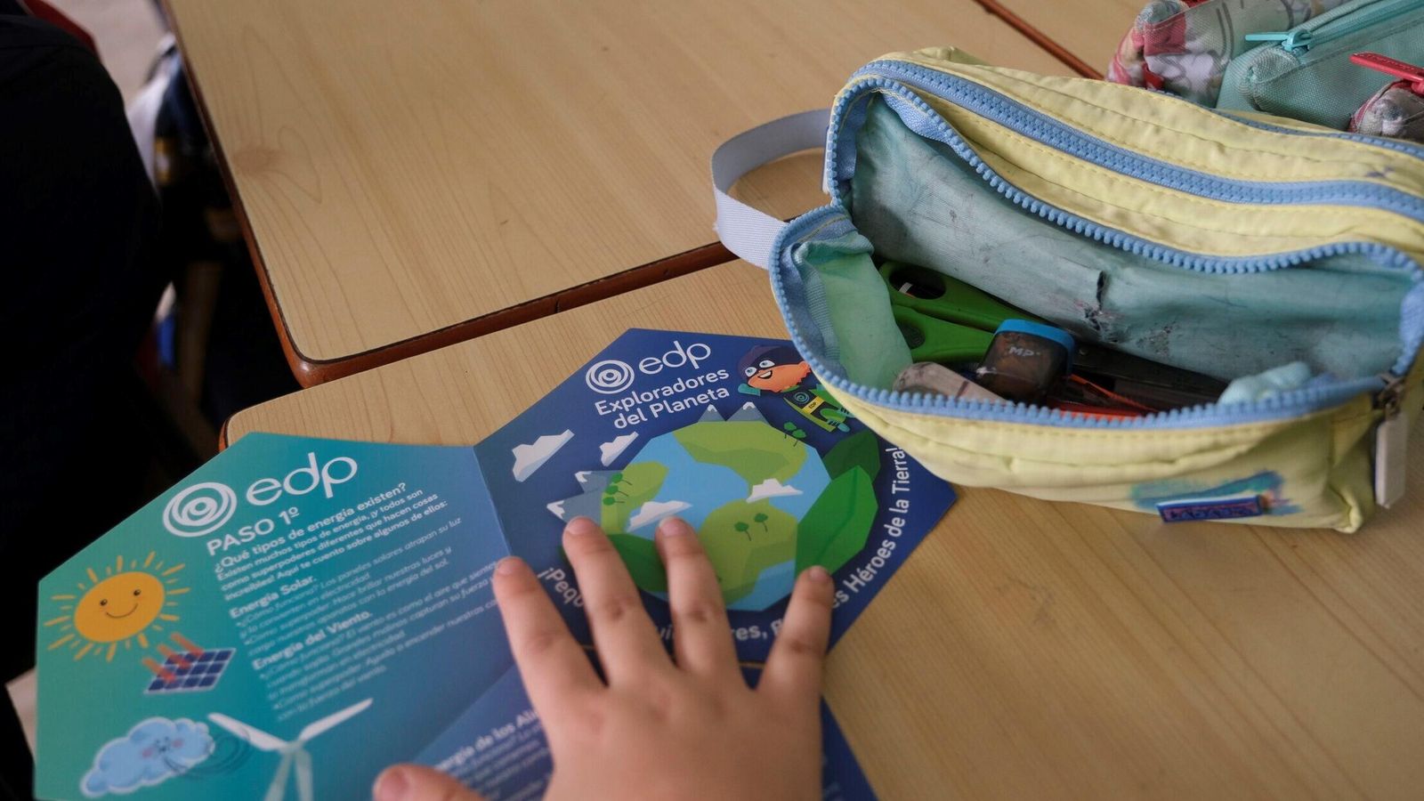 Una niña sostiene el tablero de juego para ser “exploradora del planeta”.