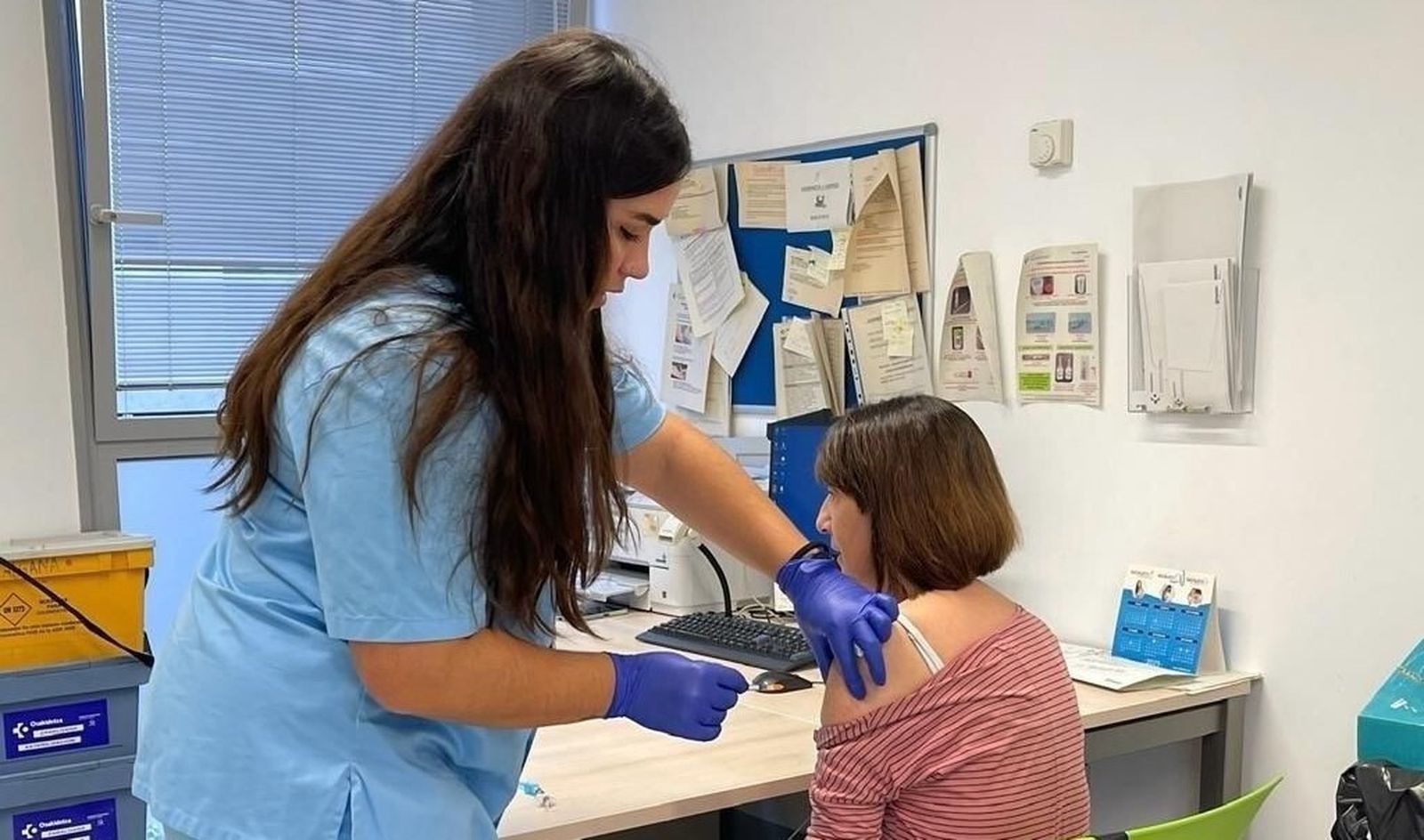 Una enfermera administra una vacuna.