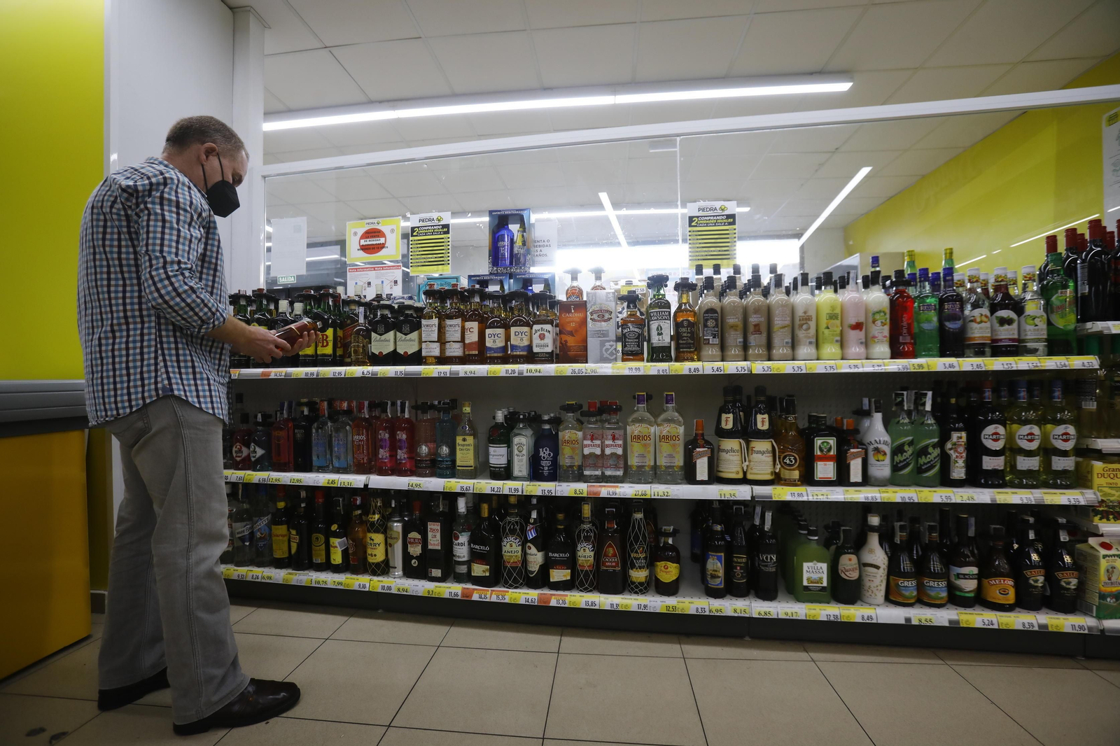 Un cliente del supermercado Piedra de la calle Previsión en el pasillo de las bebidas espirituosas.