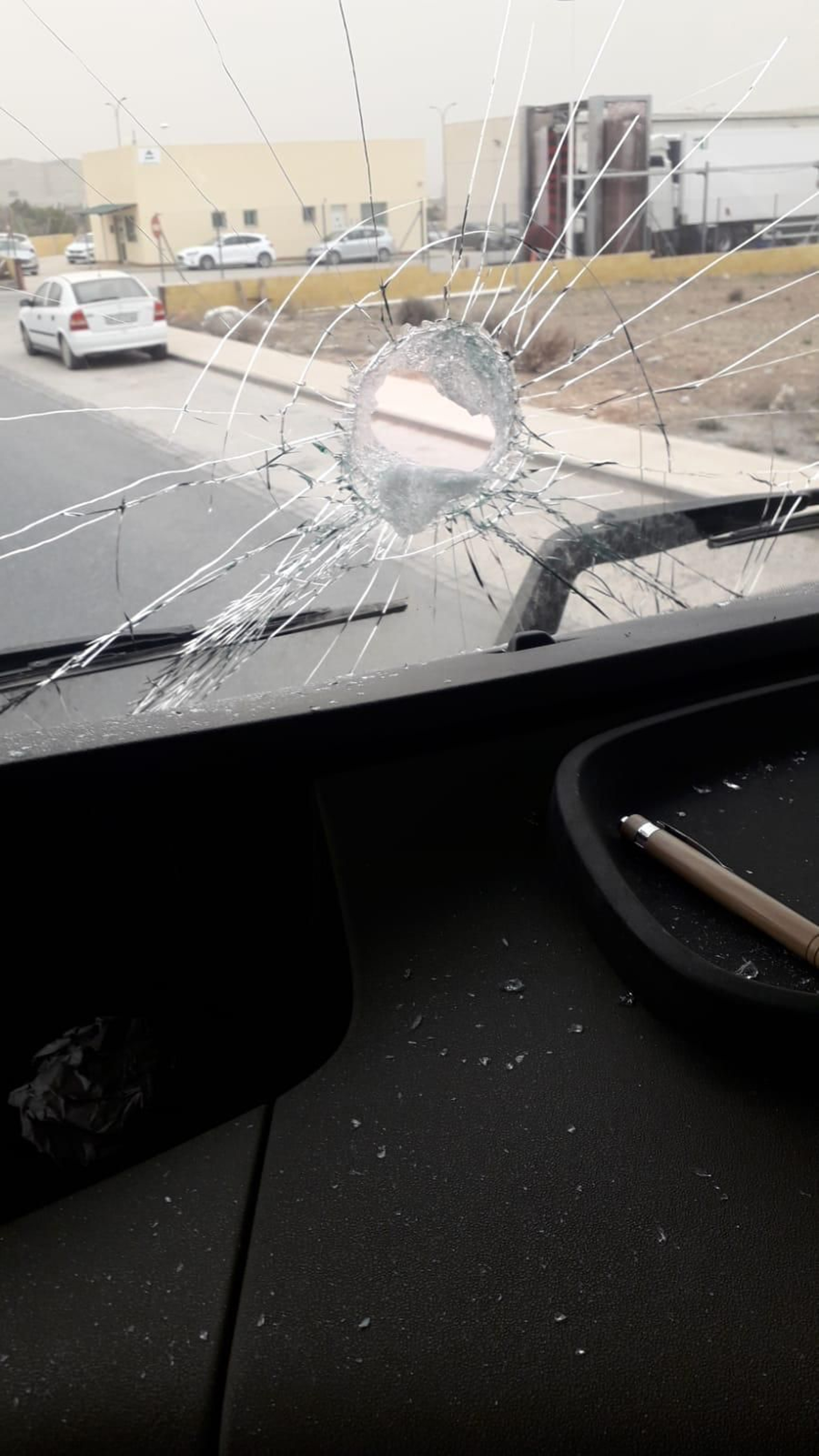 El impacto de una piedra en la lunar delantera de otro camión.