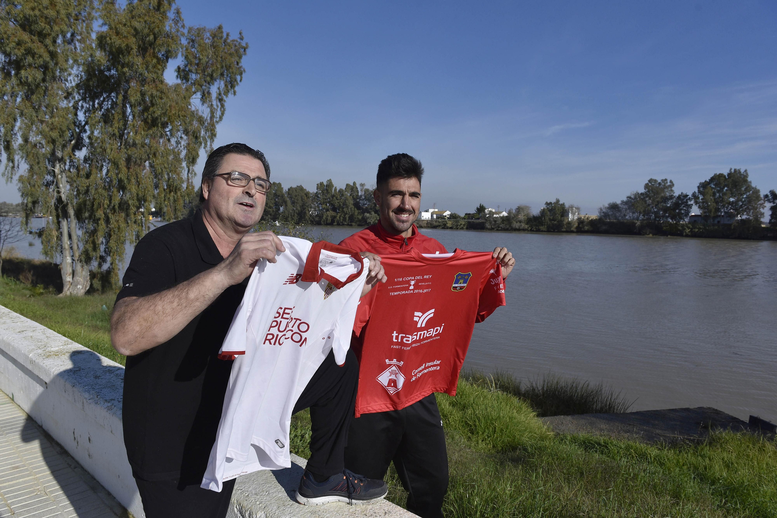Curro y Juan Antonio, padre e hijo, posan en la orilla del Guadalquivir con las camisetas del Sevilla y del Formentera.