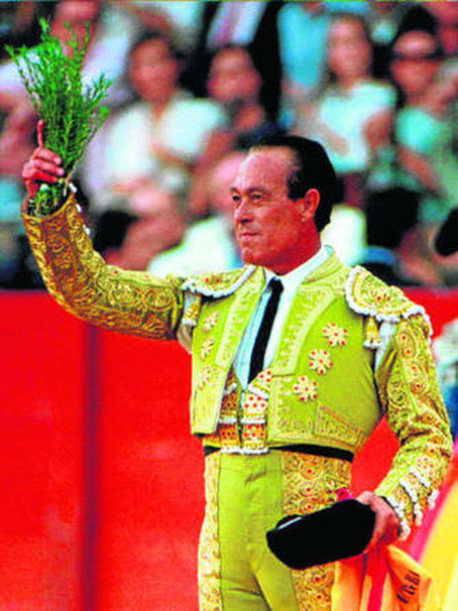 Curro Romero, en una de sus tardes de gloria, responde al cariño de Sevilla con un manojo de romero en las manos.