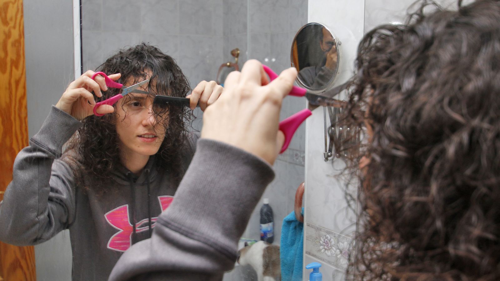 María del Mar, con peine y tijera, cortándose el flequillo.