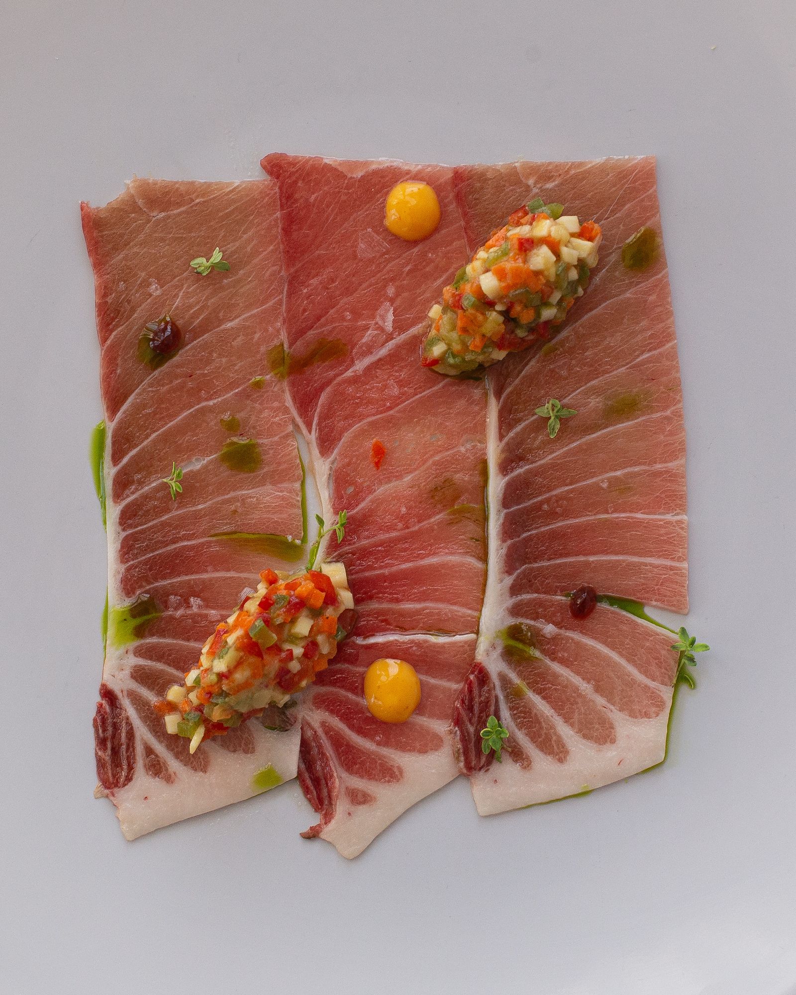 Ventresca en láminas acompañada de verduritas semicocidas en naranjas del Tesorillo