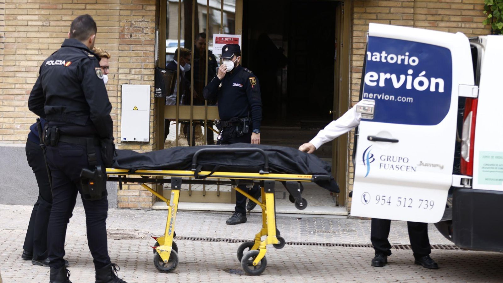 Policías y operarios del servicio funerario, en la retirada de los cadáveres.