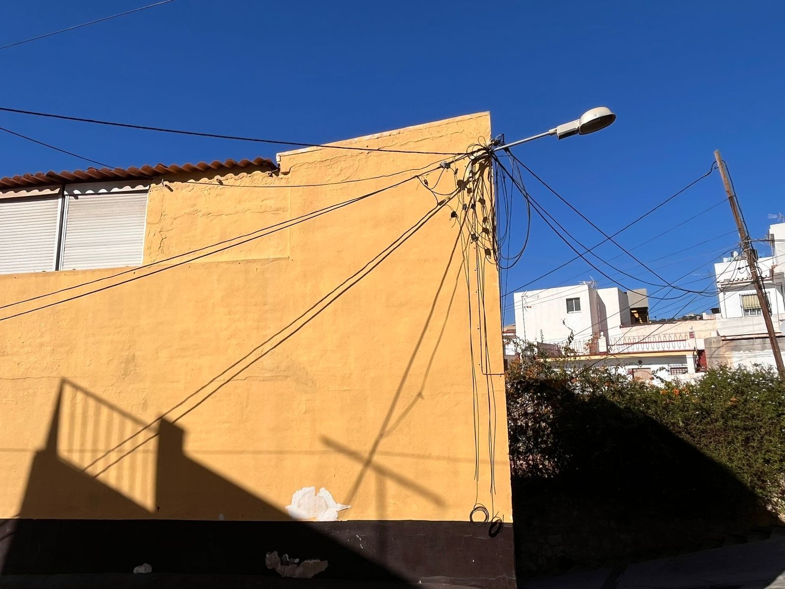 Los cables de internet sujetos a una farola debido a la ausencia de la instalación de un poste
