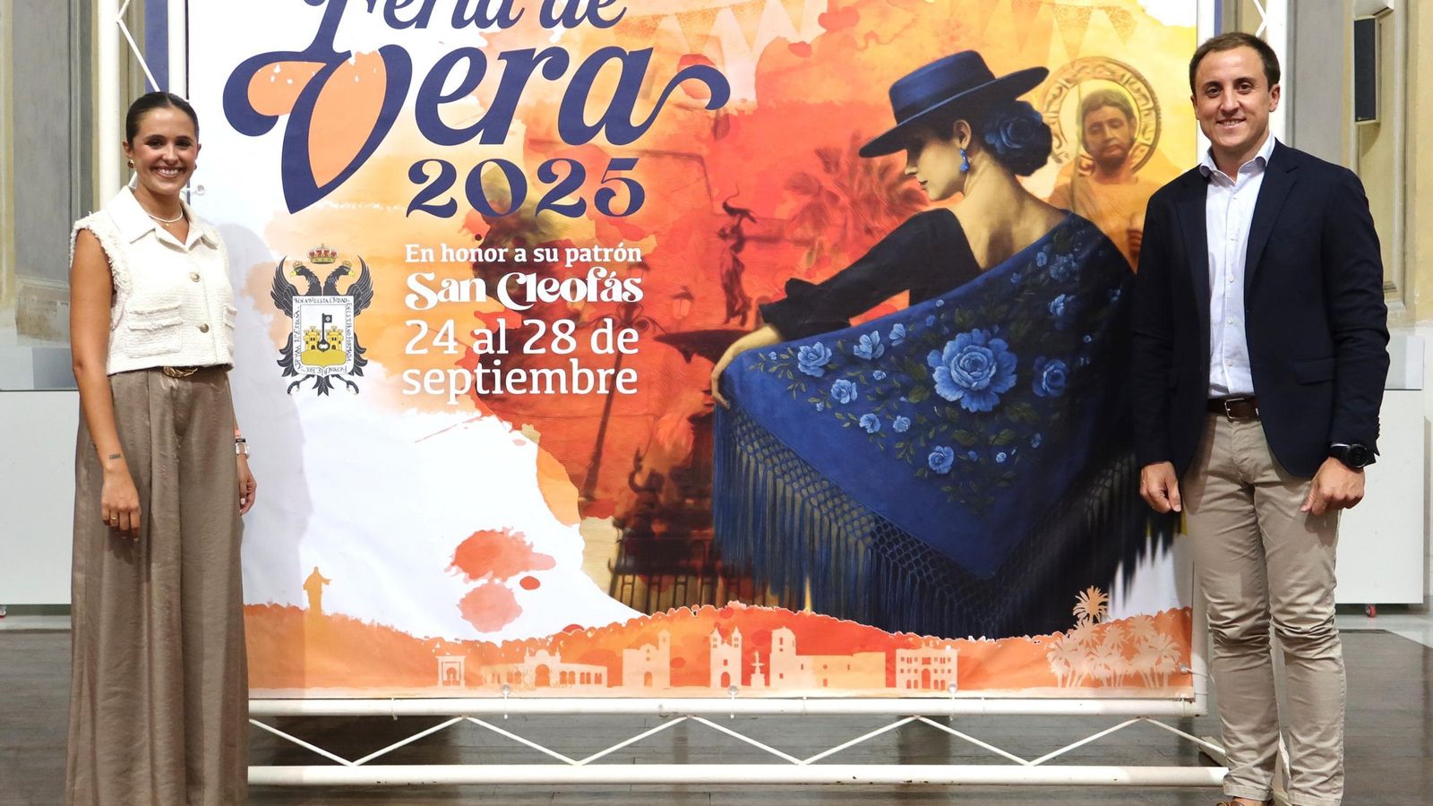 El alcalde Alfonso García y Antonia Marín, edil de Festejos, frente al cartel anunciador de la Feria veratense.