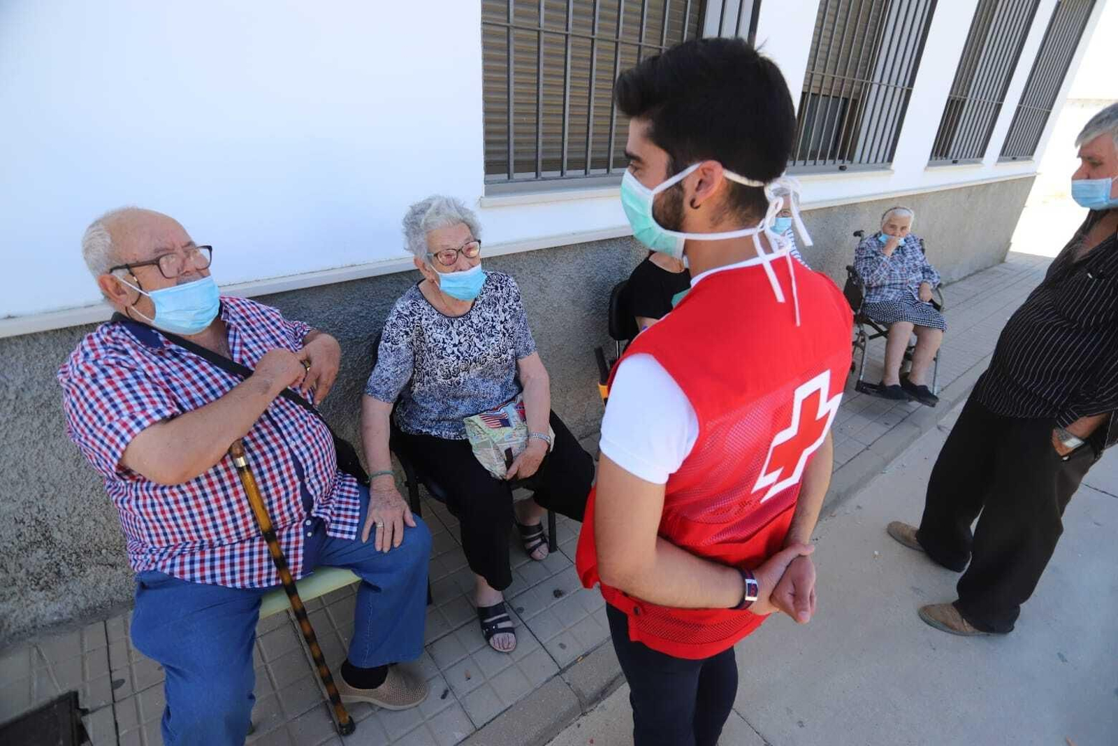 Un voluntario de Cruz Roja conversa con varias personas desalojadas de La Zarza-Perrunal