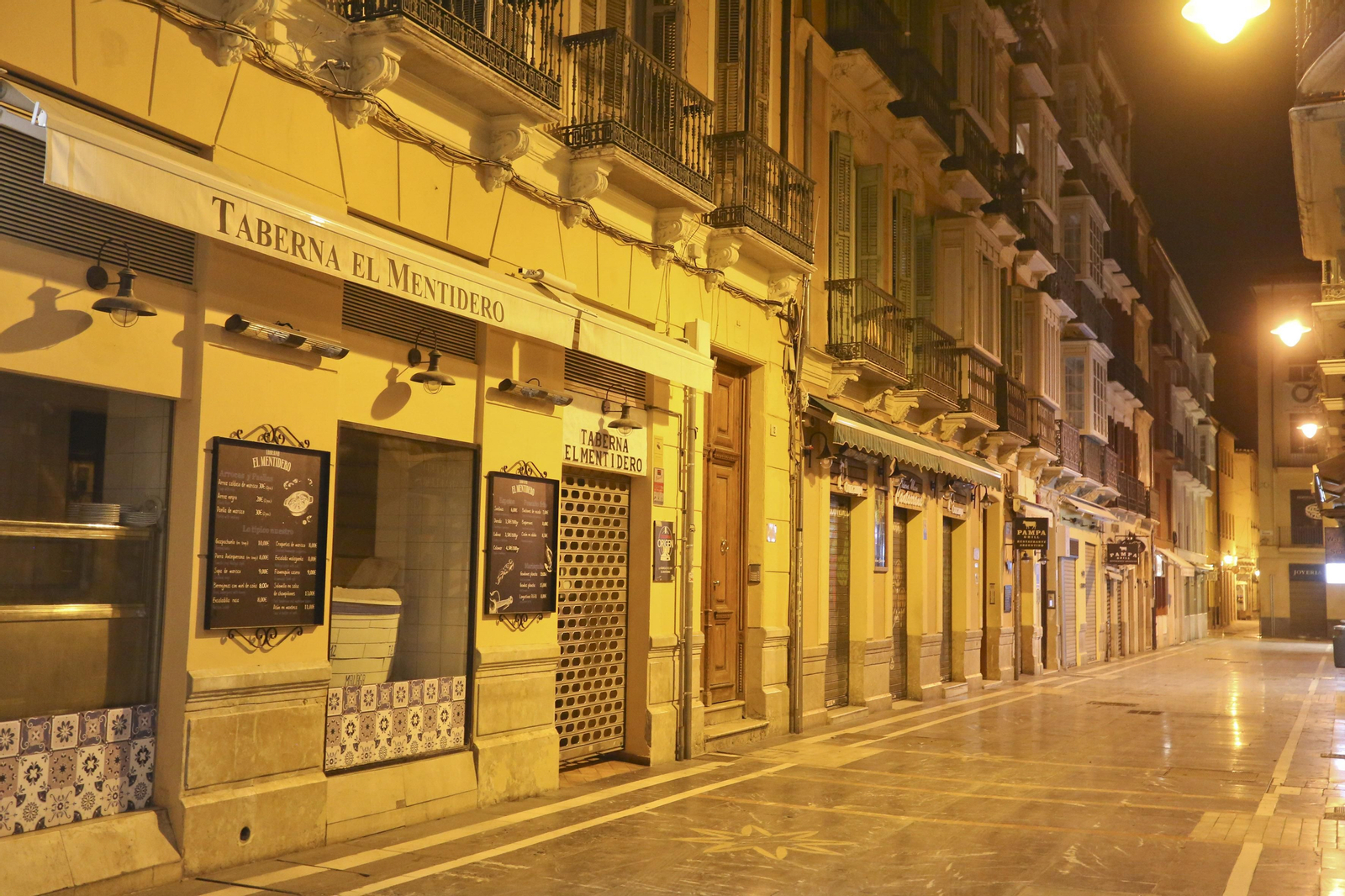 El coronavirus dibuja una noche desierta en el centro de Málaga, en fotos