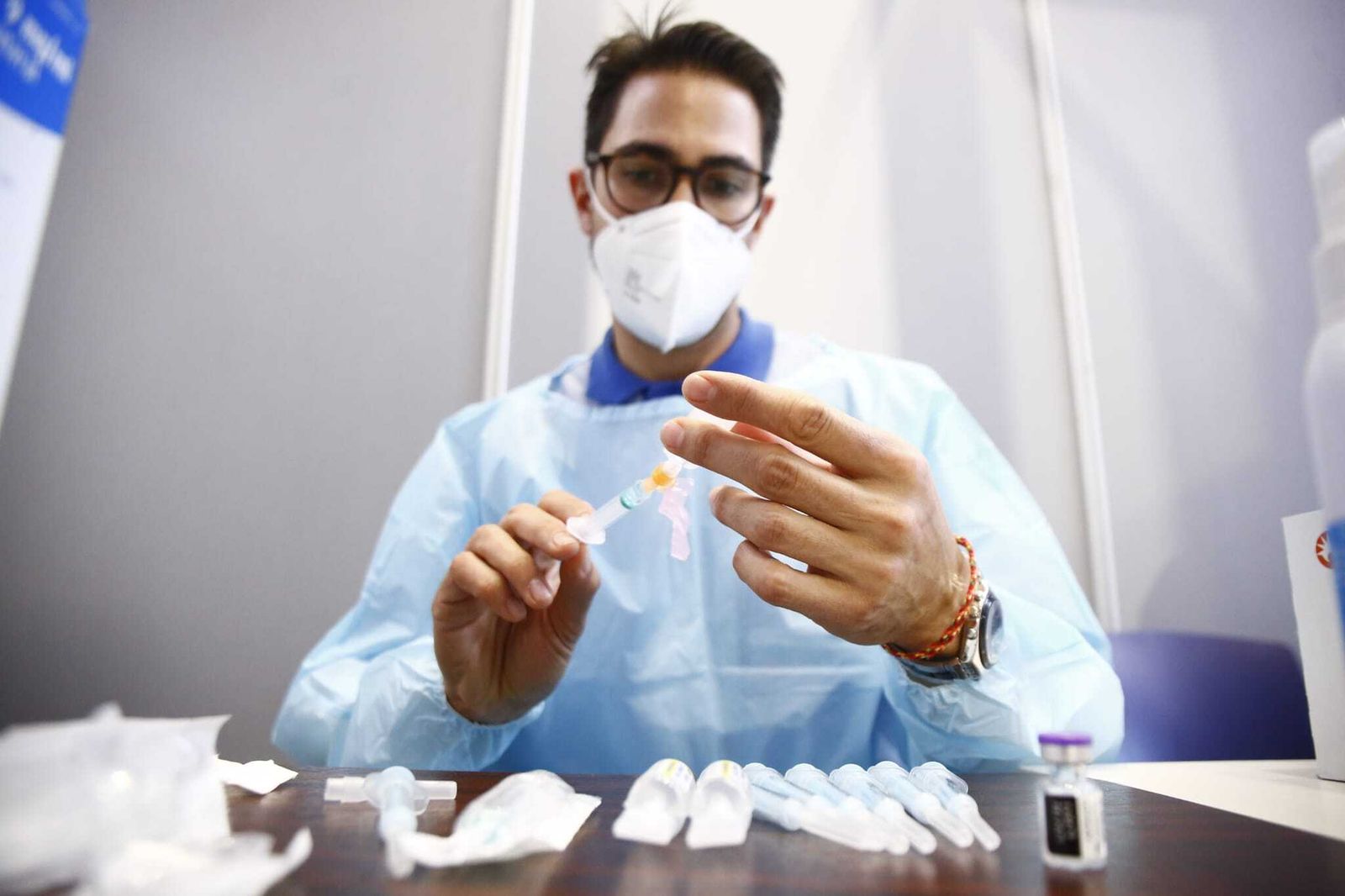 Un enfermero manipulando una vacuna en un puesto de inoculación.