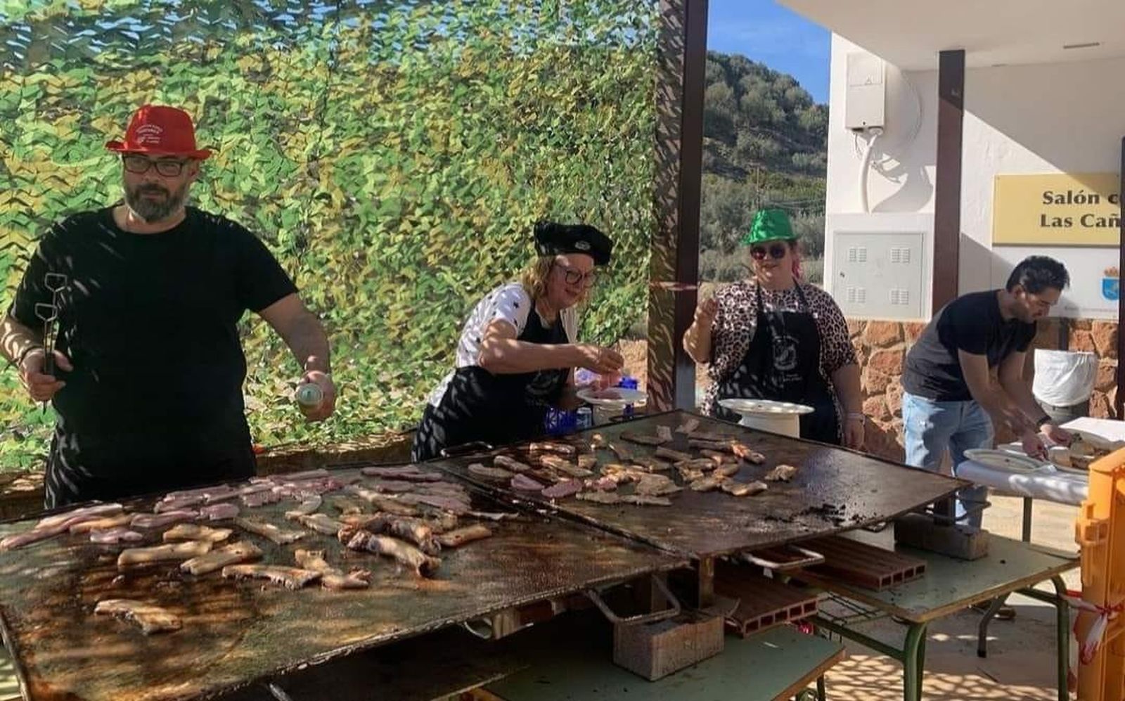 La banda de música en la elaboración de la carne a la parrilla.